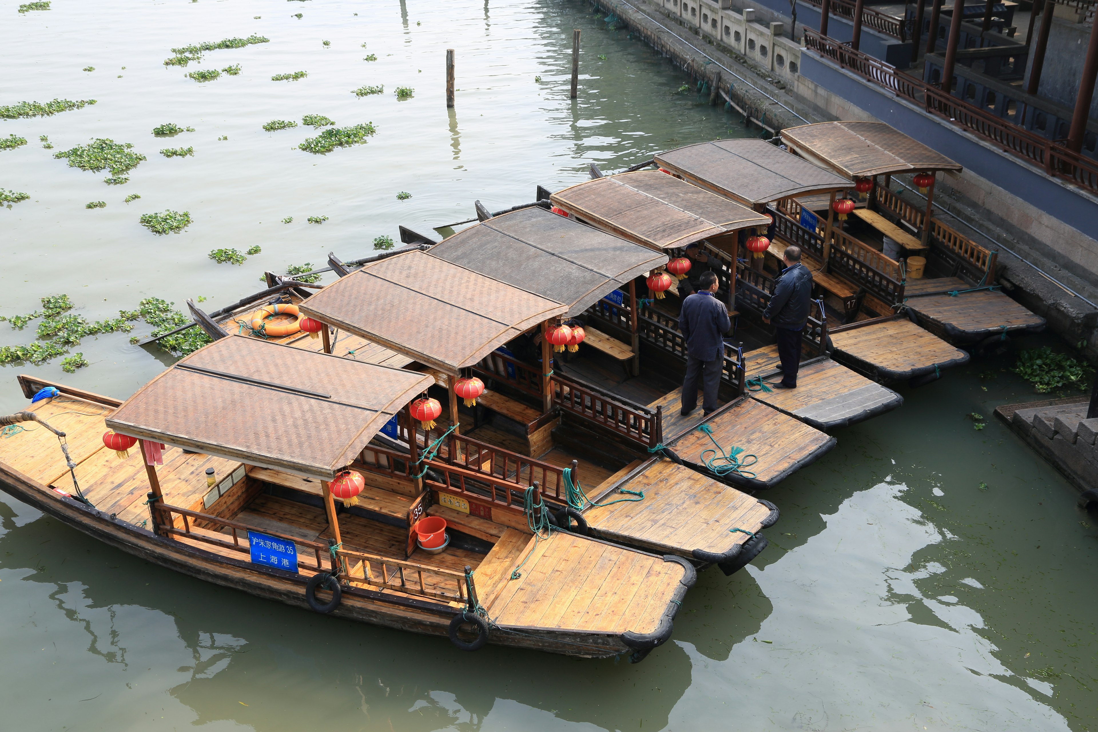 Bateaux traditionnels amarrés au bord de l'eau avec des personnes montant et descendant