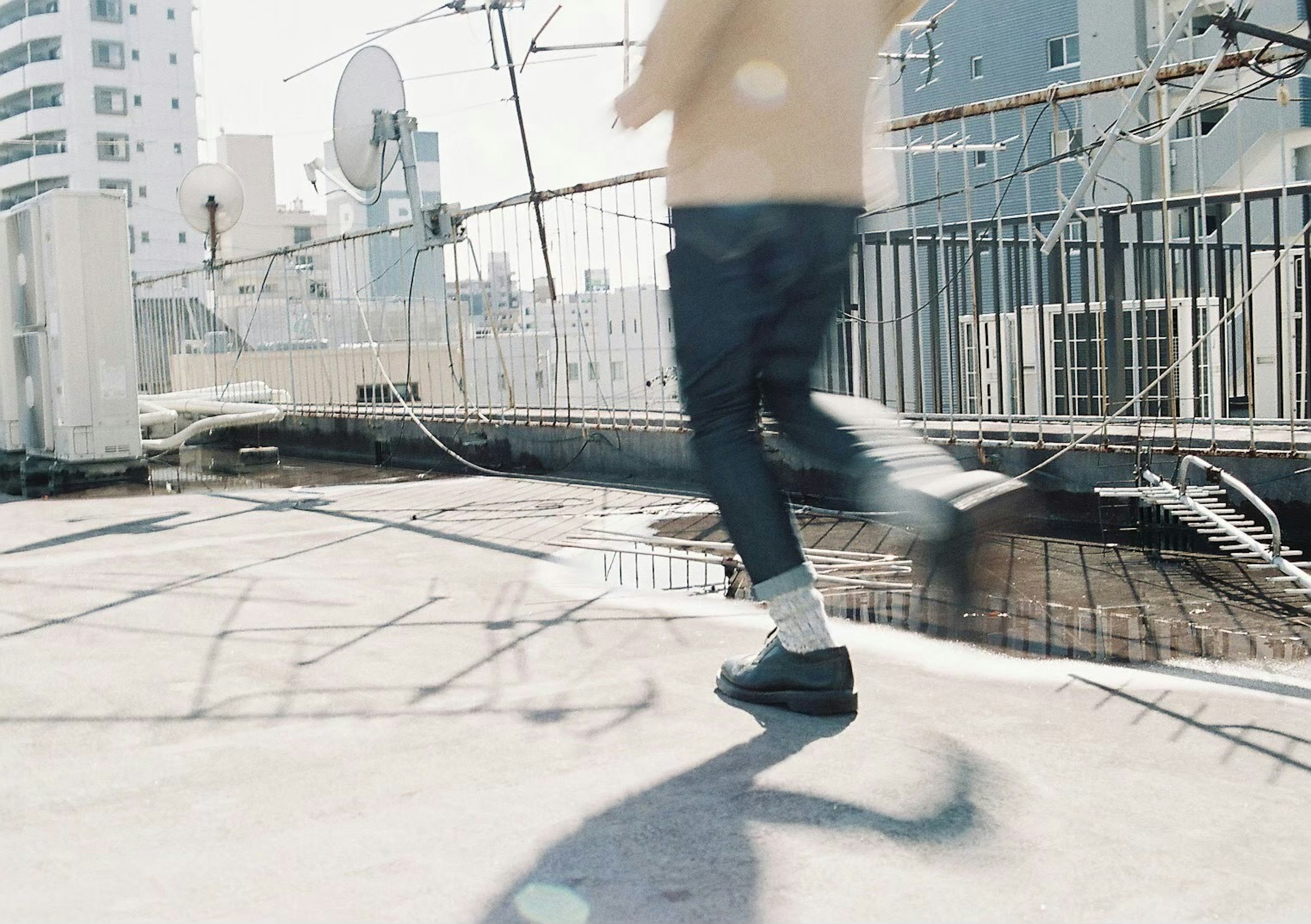 A person running on a rooftop with a cityscape background