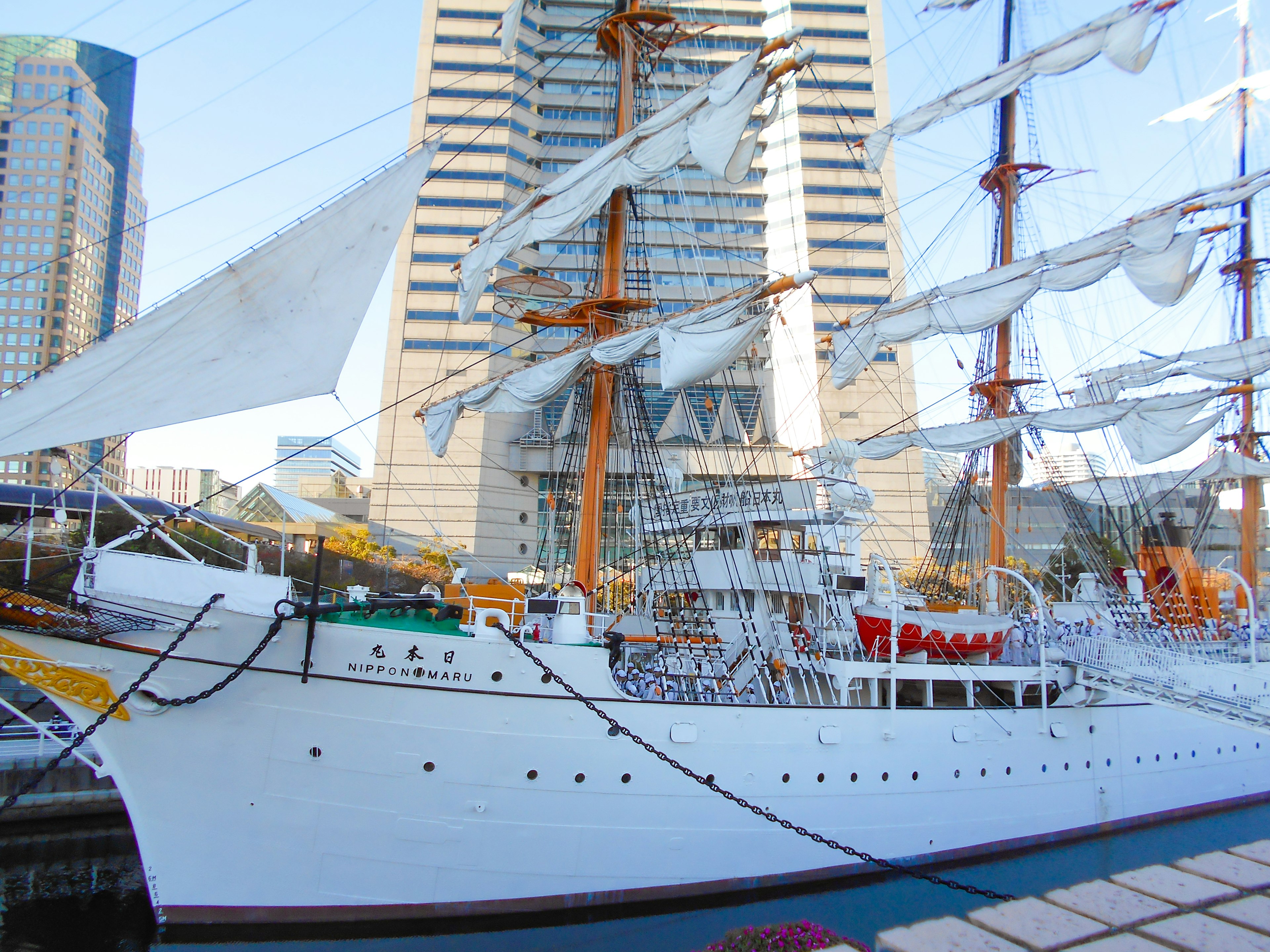 Side view of a sailing ship with skyscrapers in the background