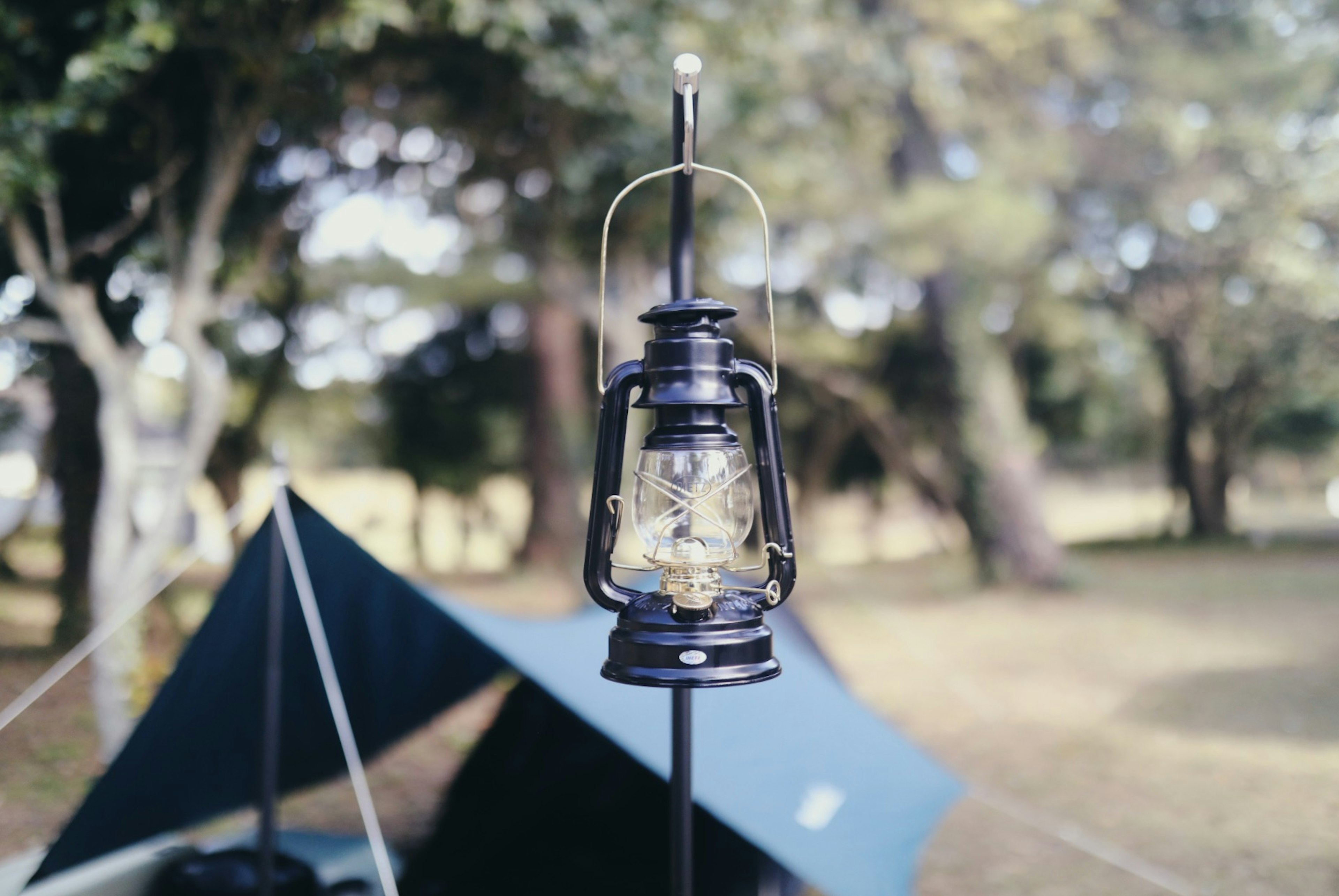 Black lantern hanging at a campsite with a tent