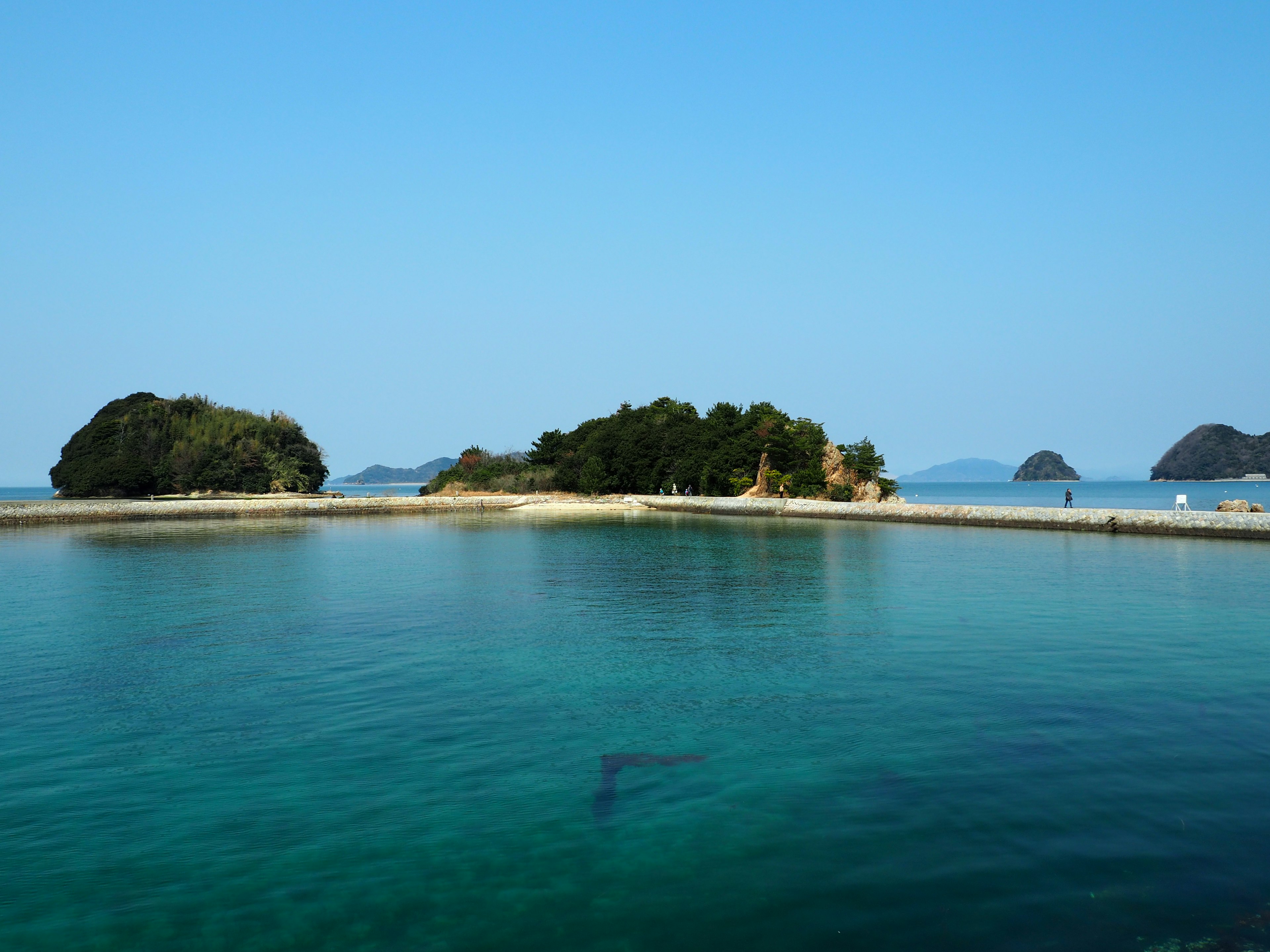 青い空と透明な水に囲まれた小さな島々の風景