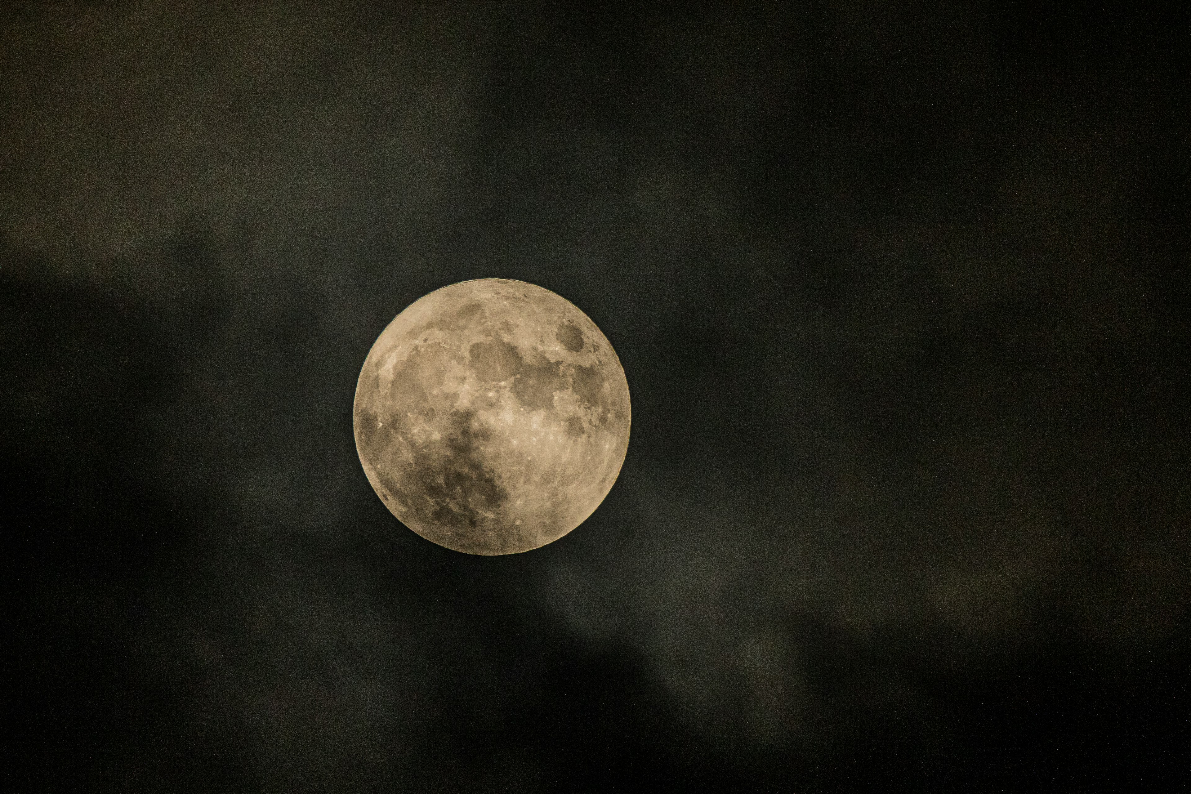 Bella luna piena che brilla attraverso nuvole scure