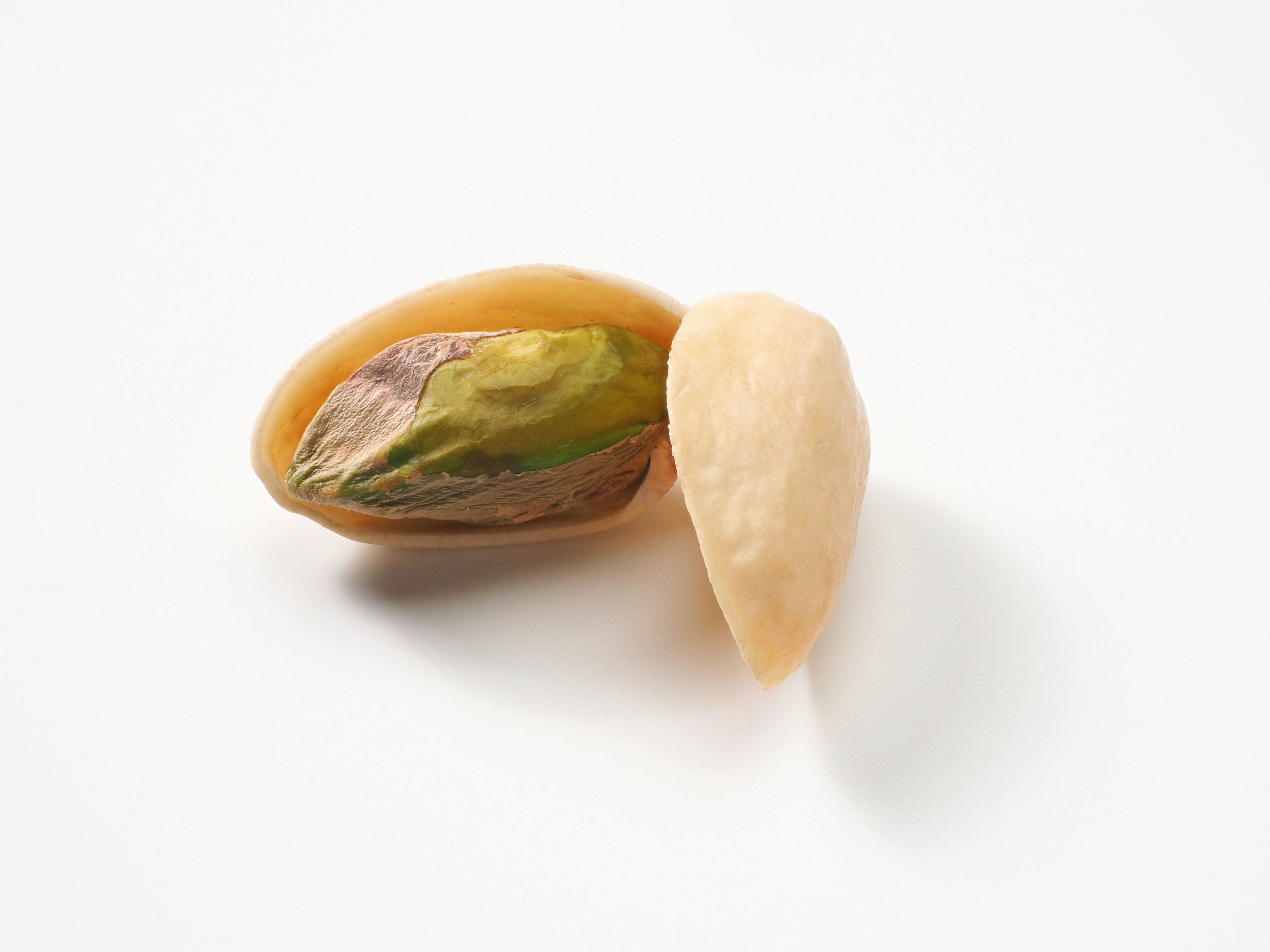 Pistachio shell with green nut visible inside