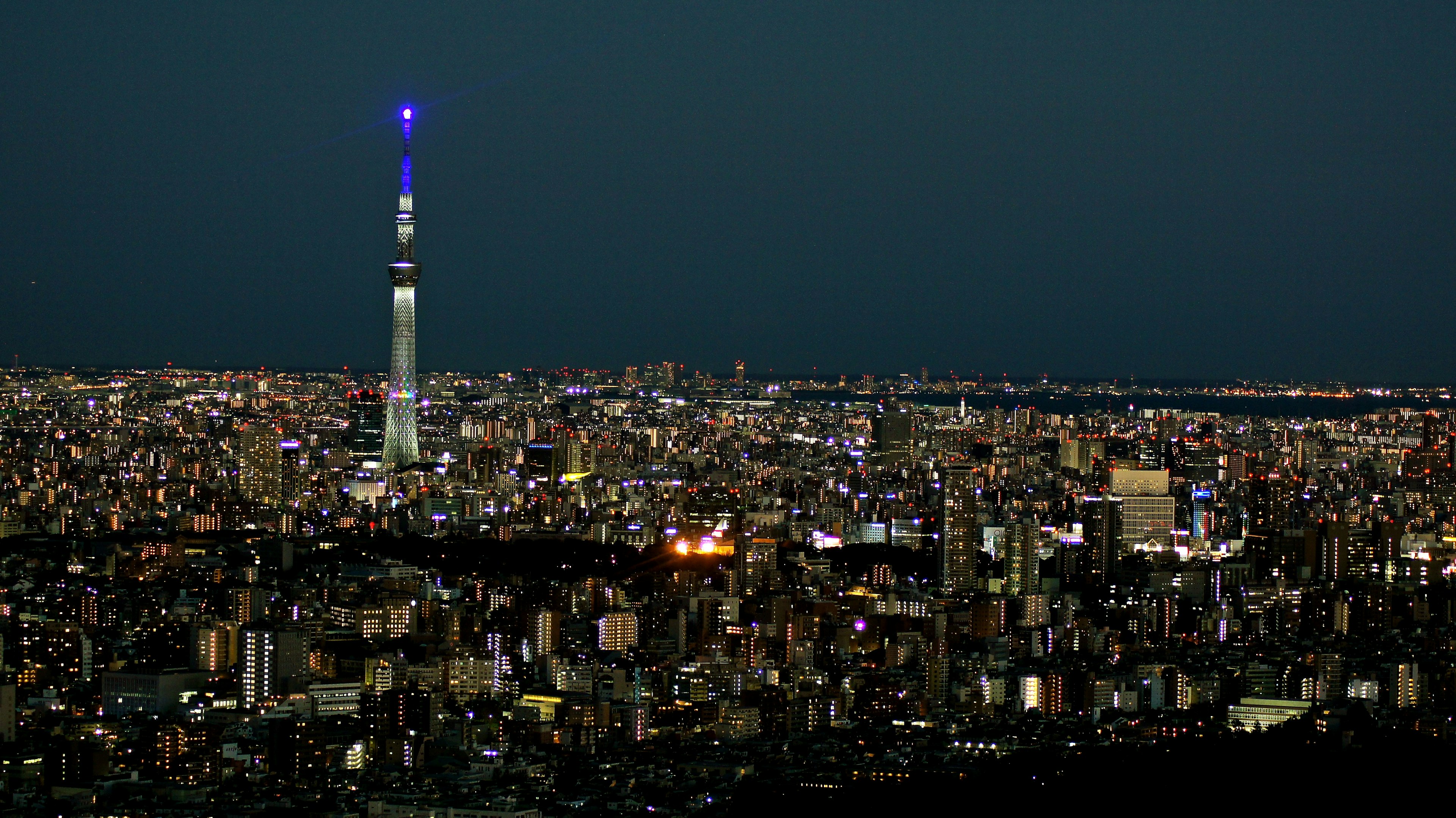 Tokyo Skytree iluminado por la noche con un horizonte urbano