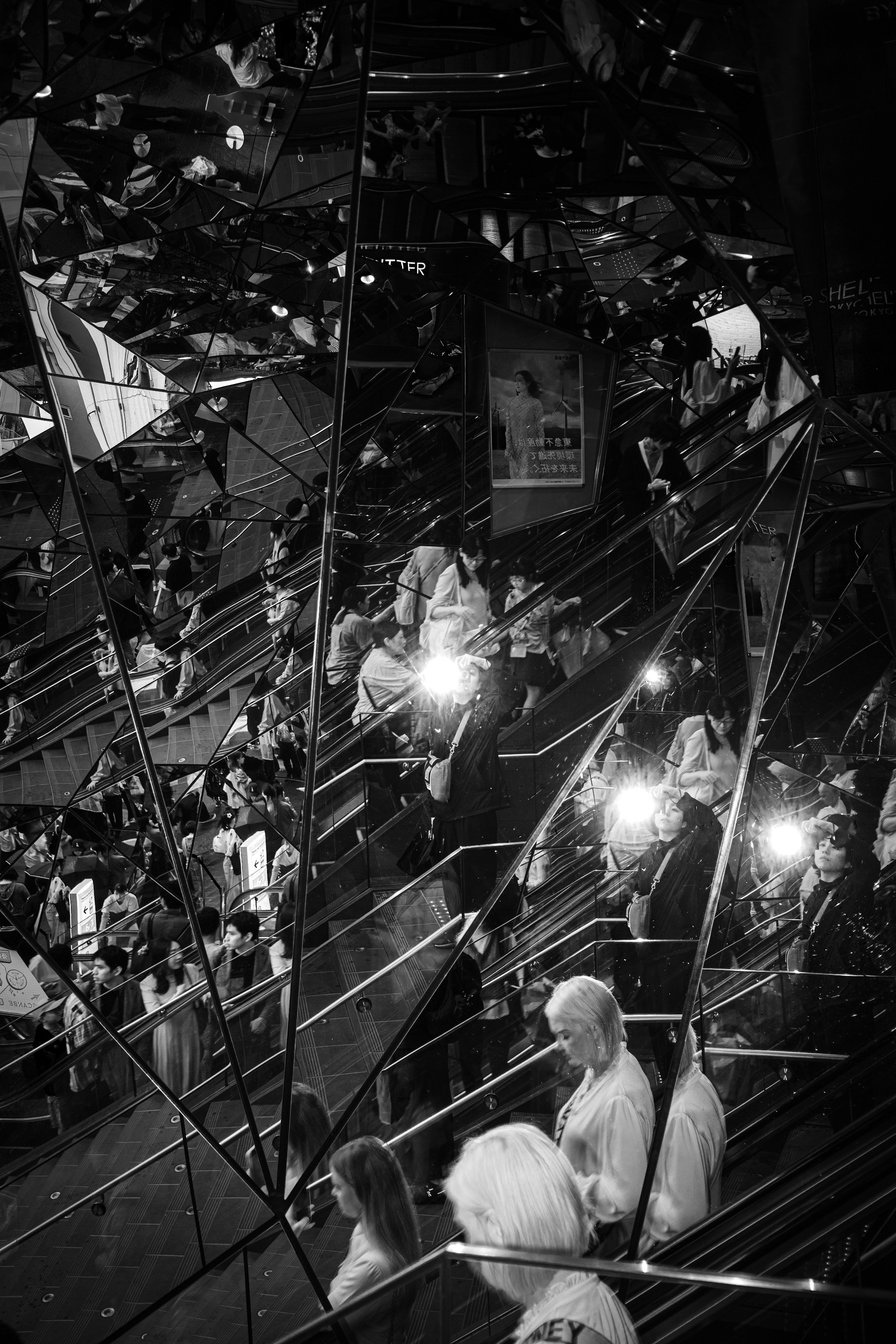 Crowded venue with striking black and white reflections and camera flashes