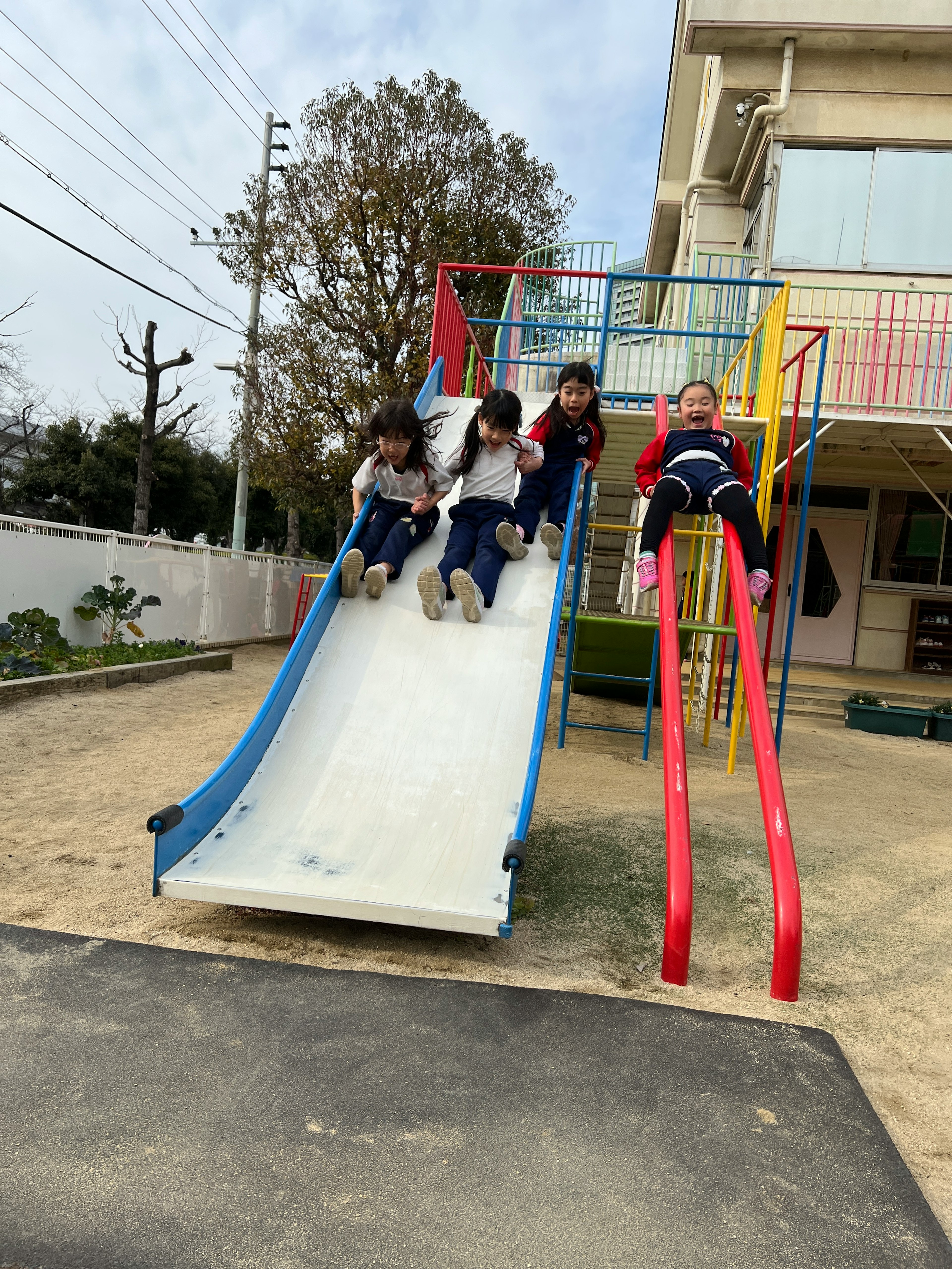 Niños jugando en un tobogán colorido en un parque