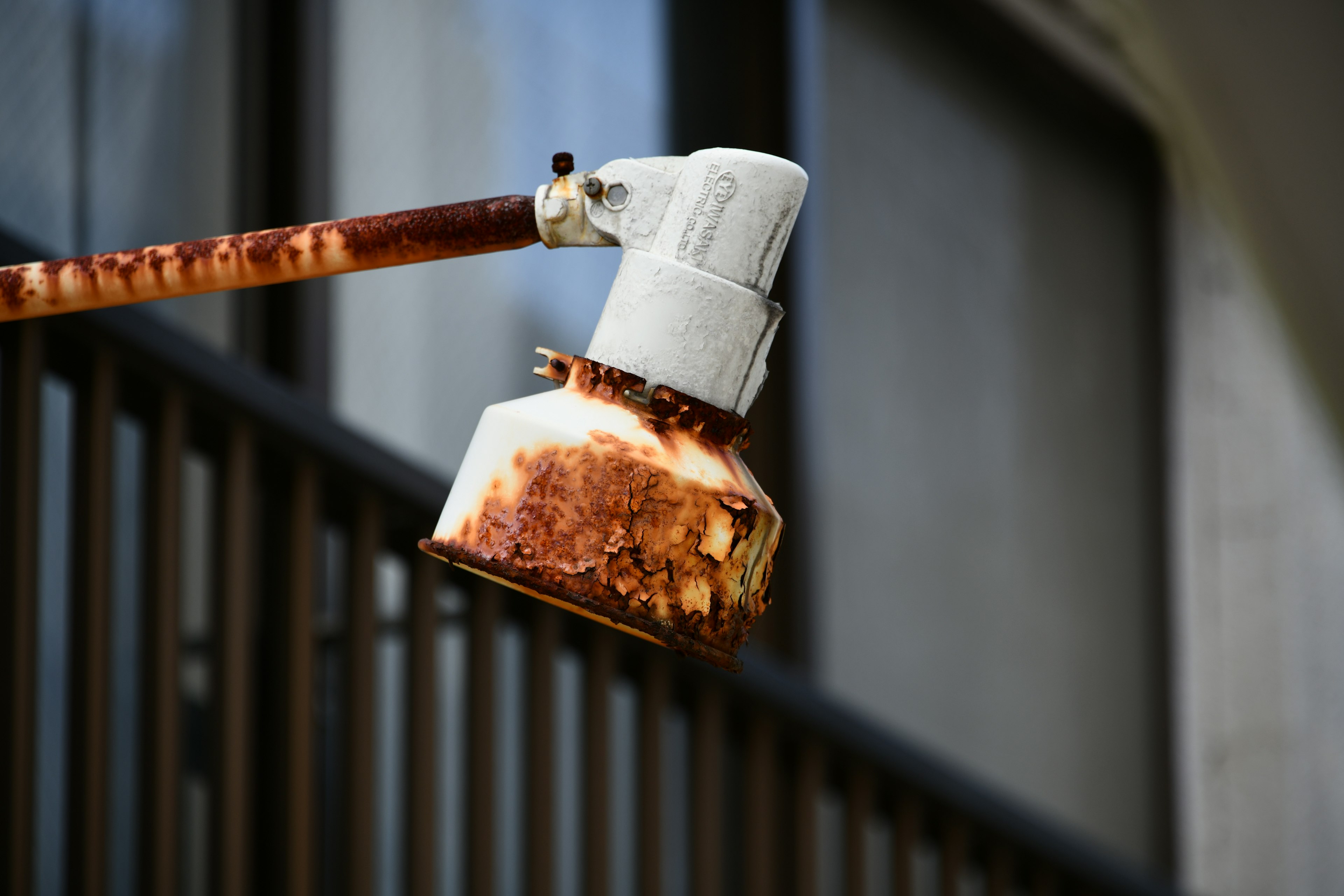 Immagine di una testa di lampada arrugginita con un lungo braccio