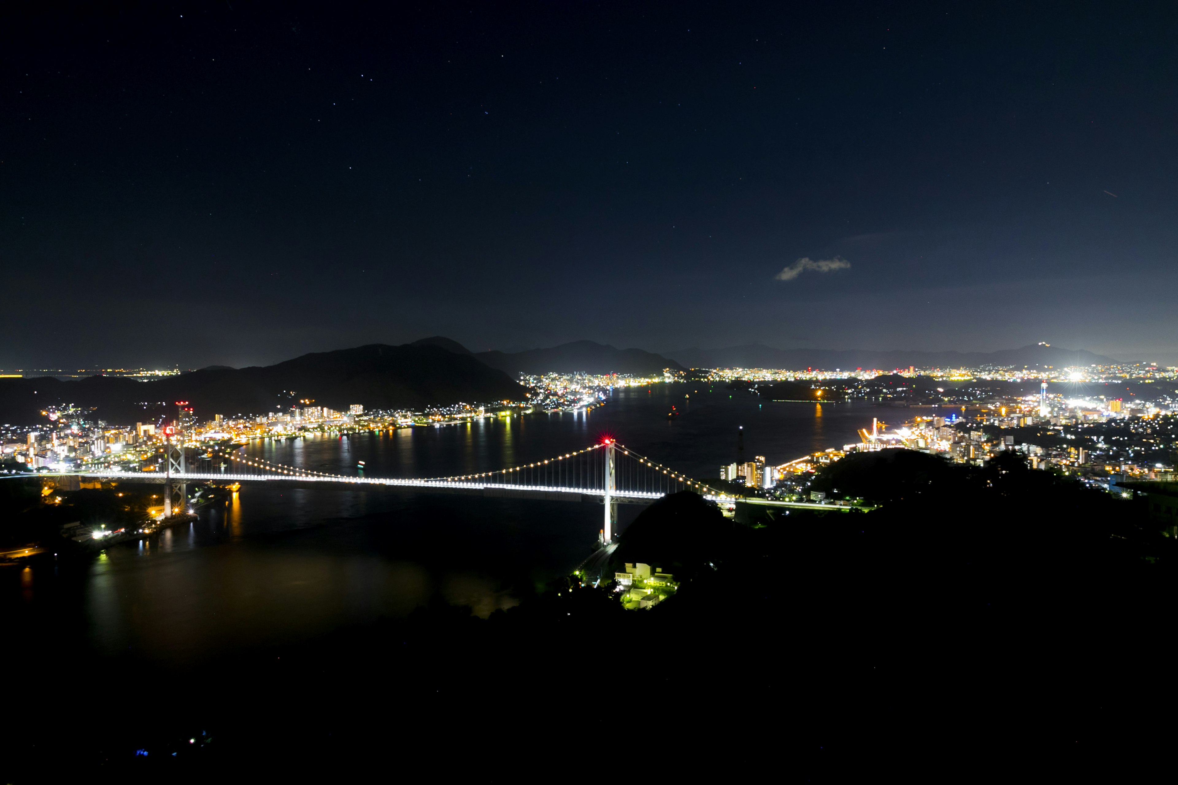 Vista panoramica di un ponte illuminato di notte con le luci della città