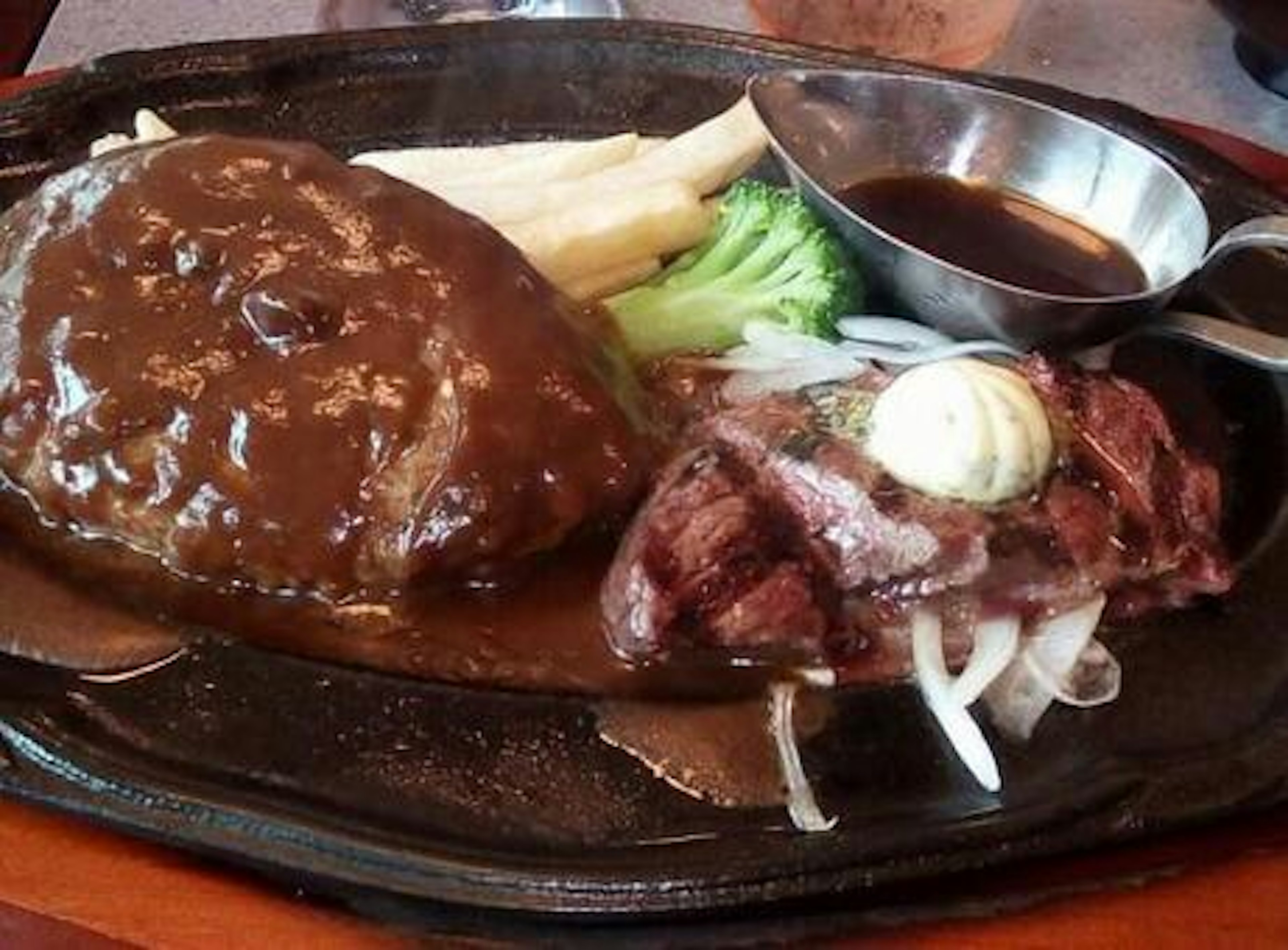 Bratplatte mit Hamburgersteak und Steak mit Gemüse und Sauce