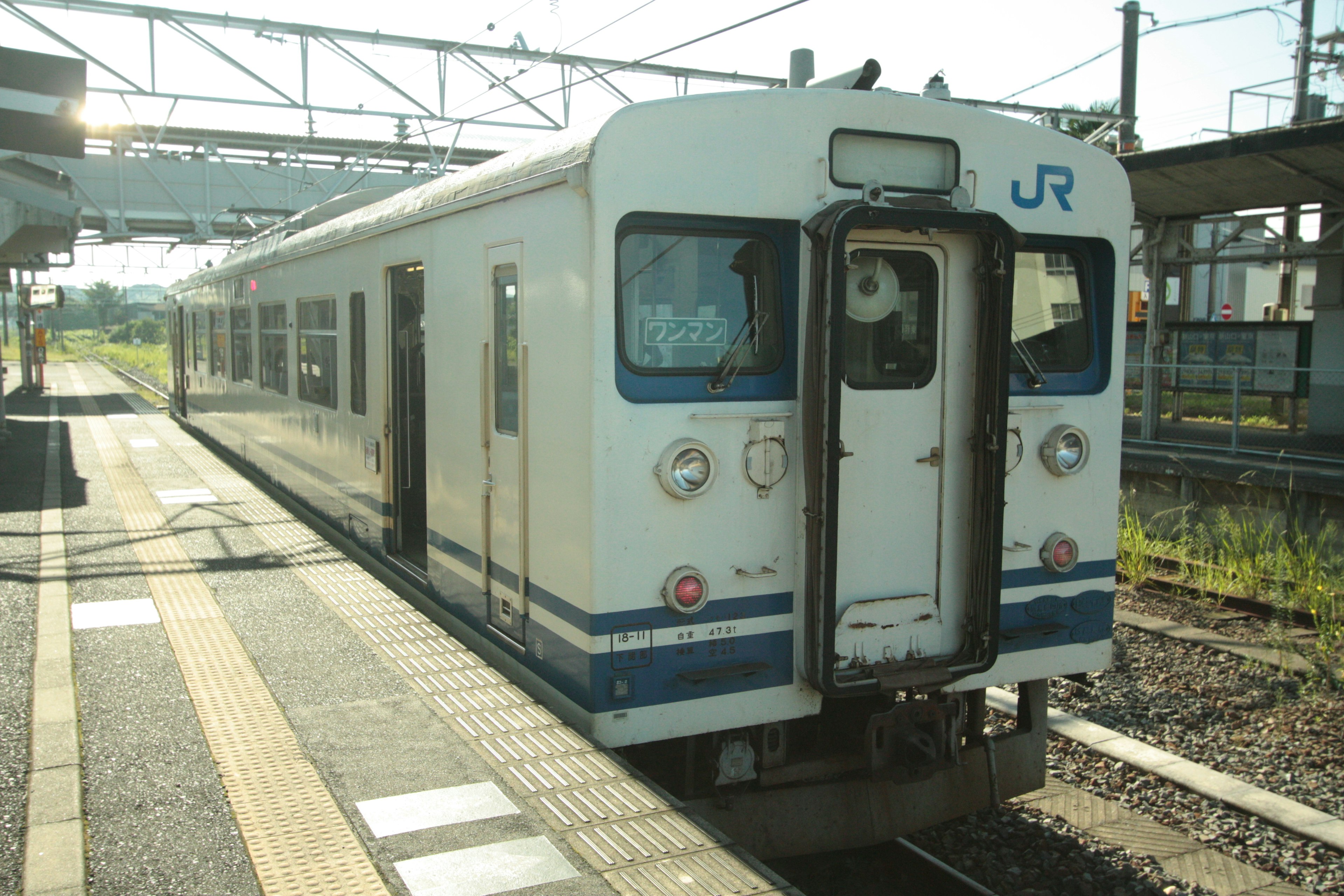 JR train parked at a station with sunlight