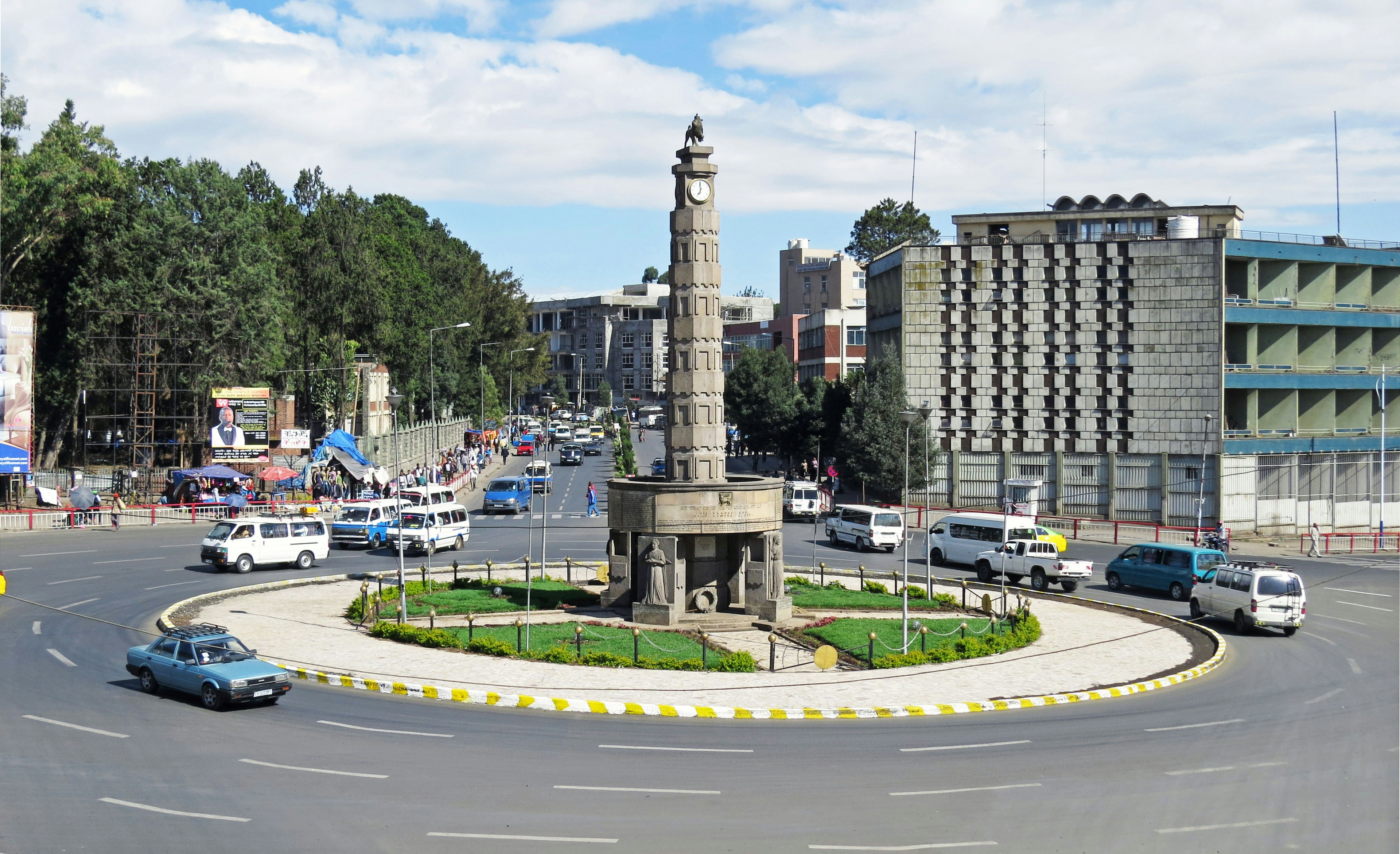 Monument in a roundabout in Nairobi with surrounding buildings