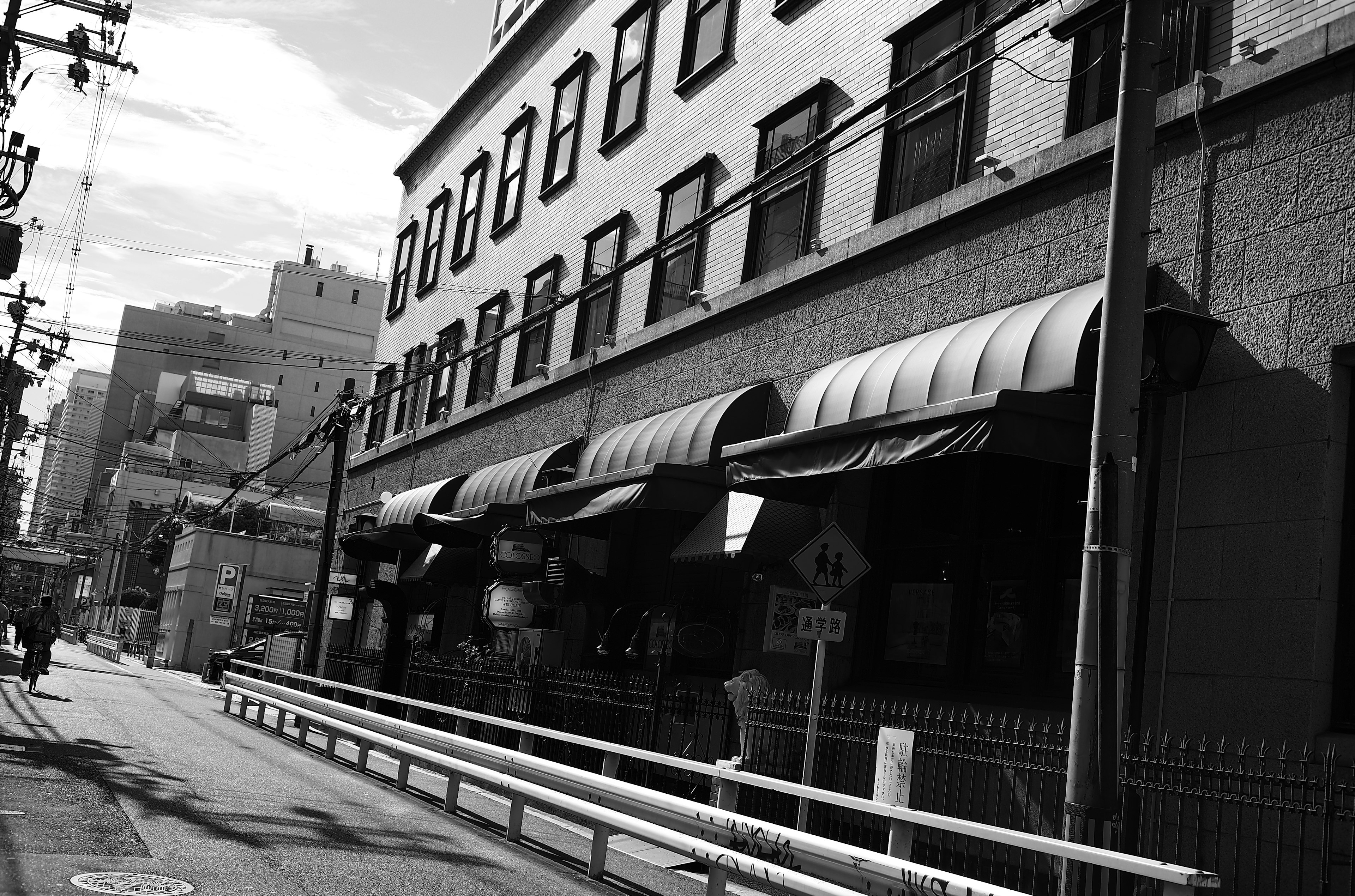 Black and white street view featuring a building with awnings