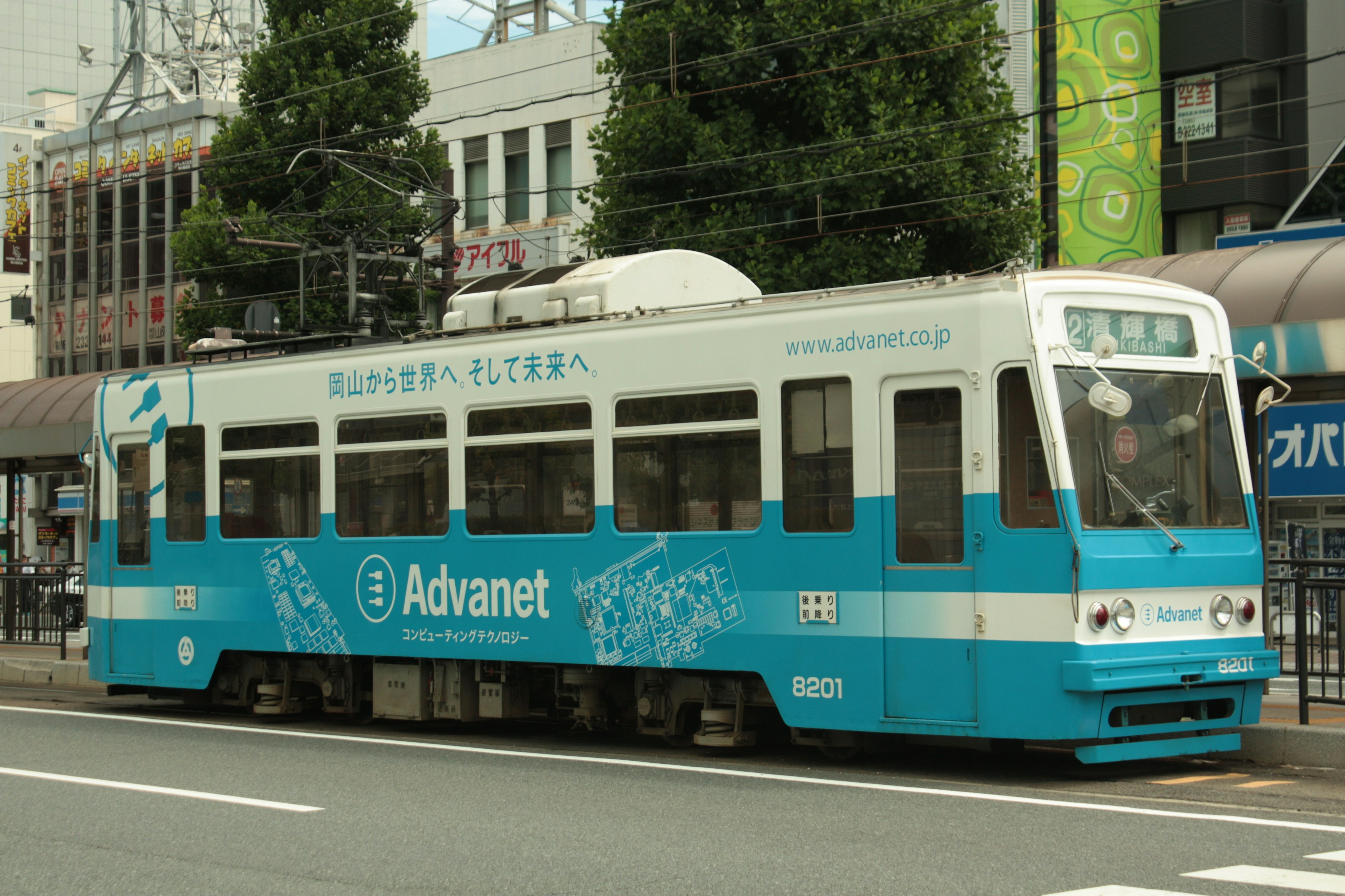 Tram blu con pubblicità parcheggiato su strada cittadina