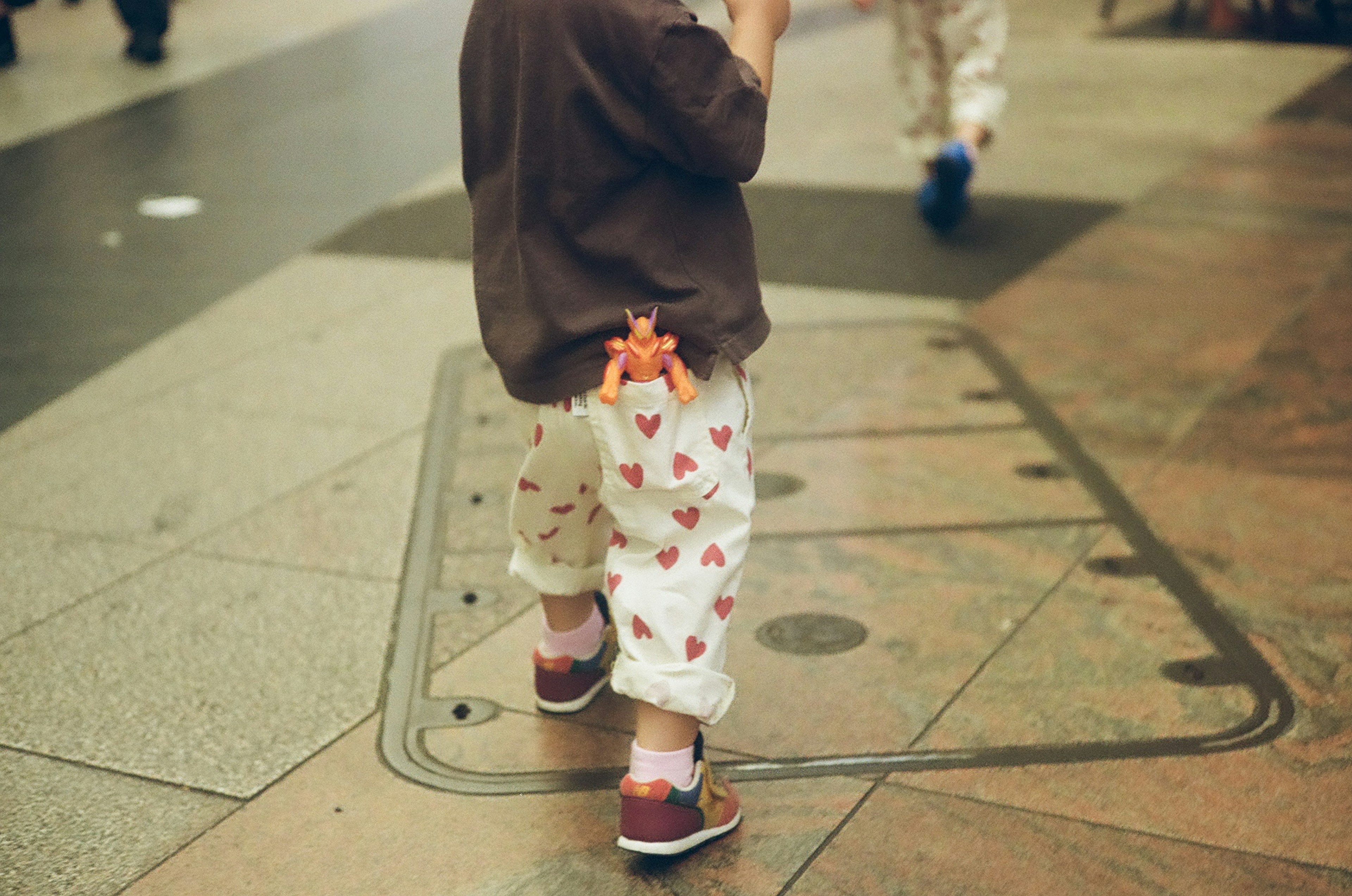 Niño con pantalones de corazones visto desde atrás