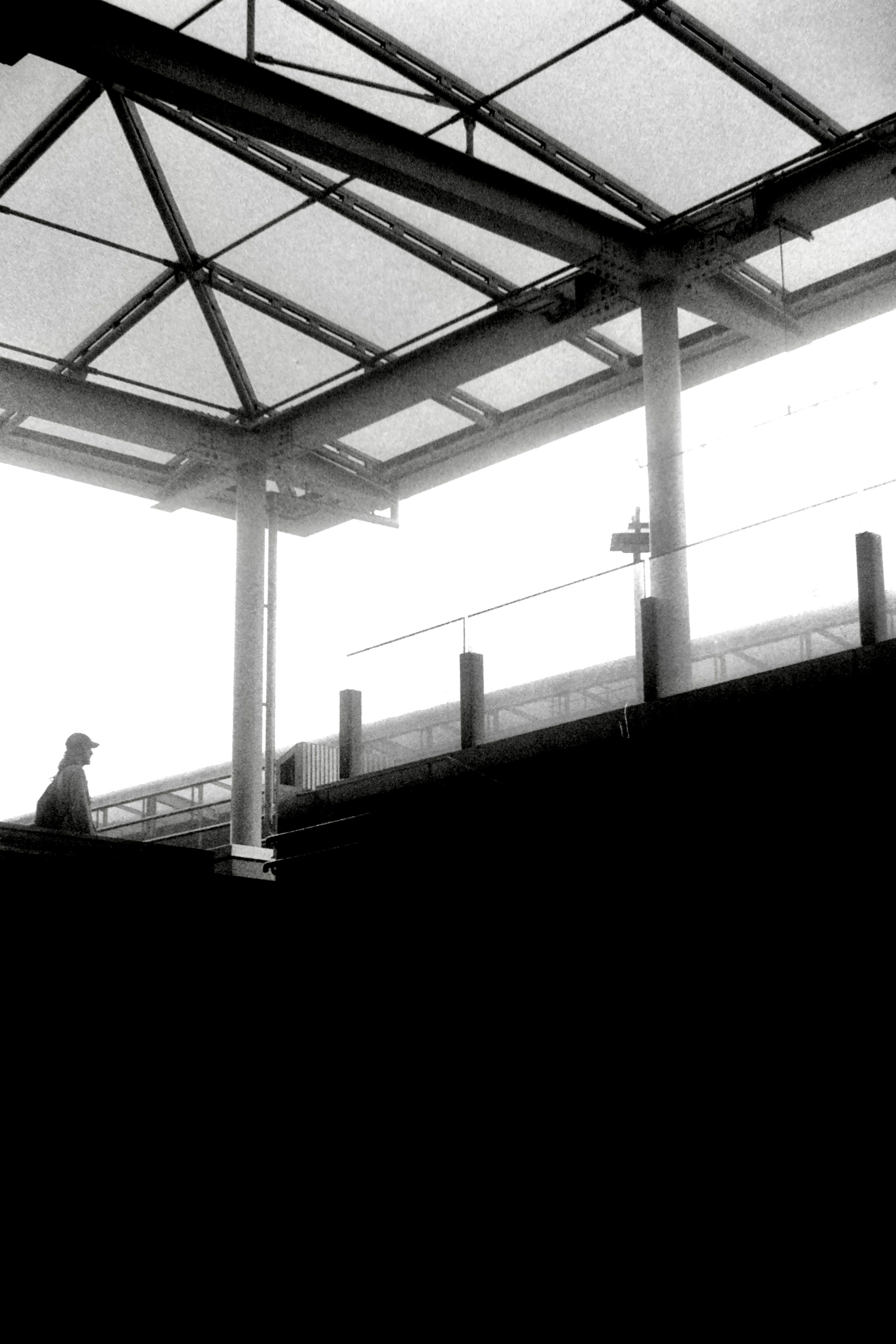 Silhouette of a person under a station roof with a geometric design