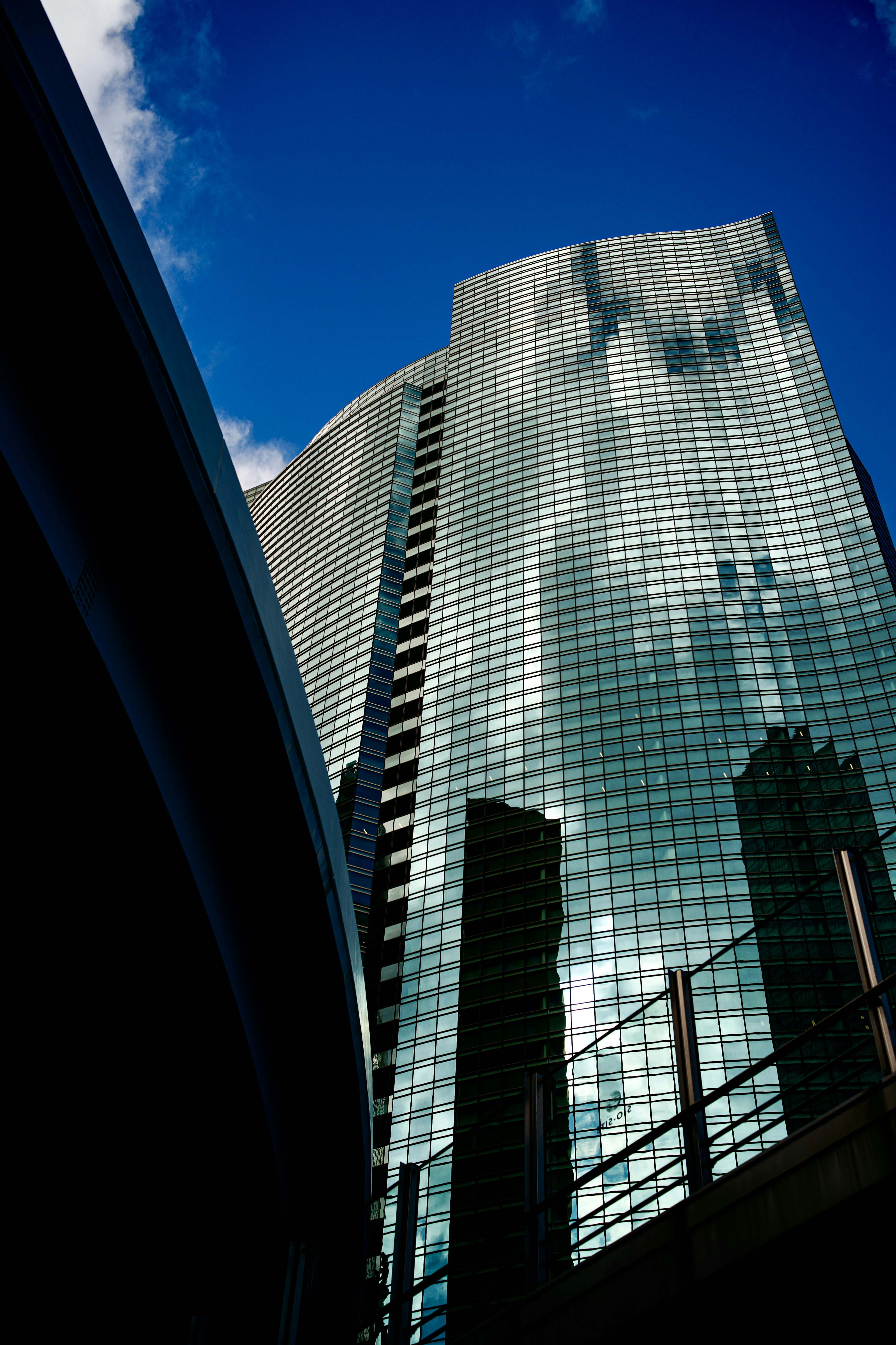 Skyscraper reflecting clouds under a blue sky