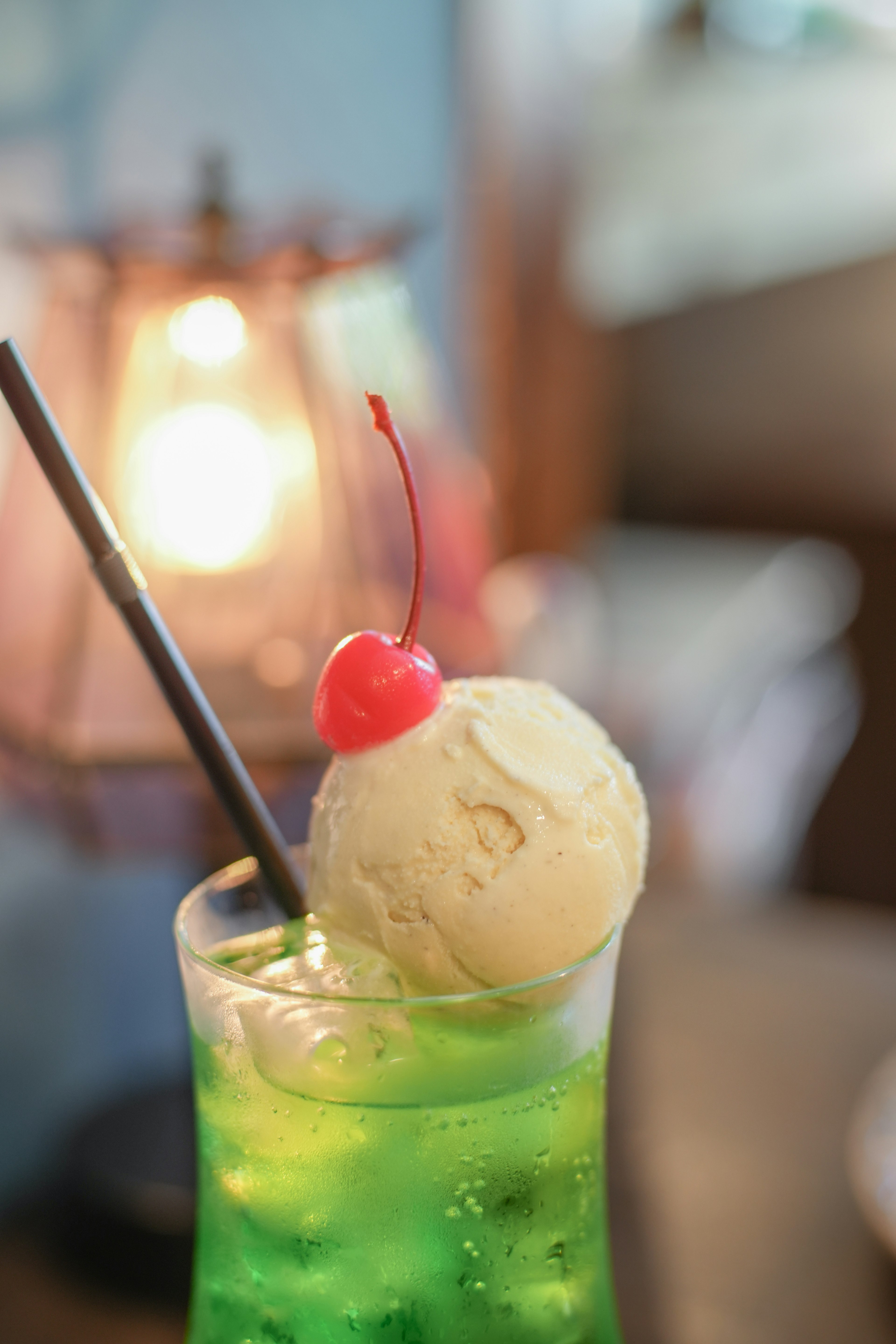 Green beverage topped with a scoop of ice cream and a cherry