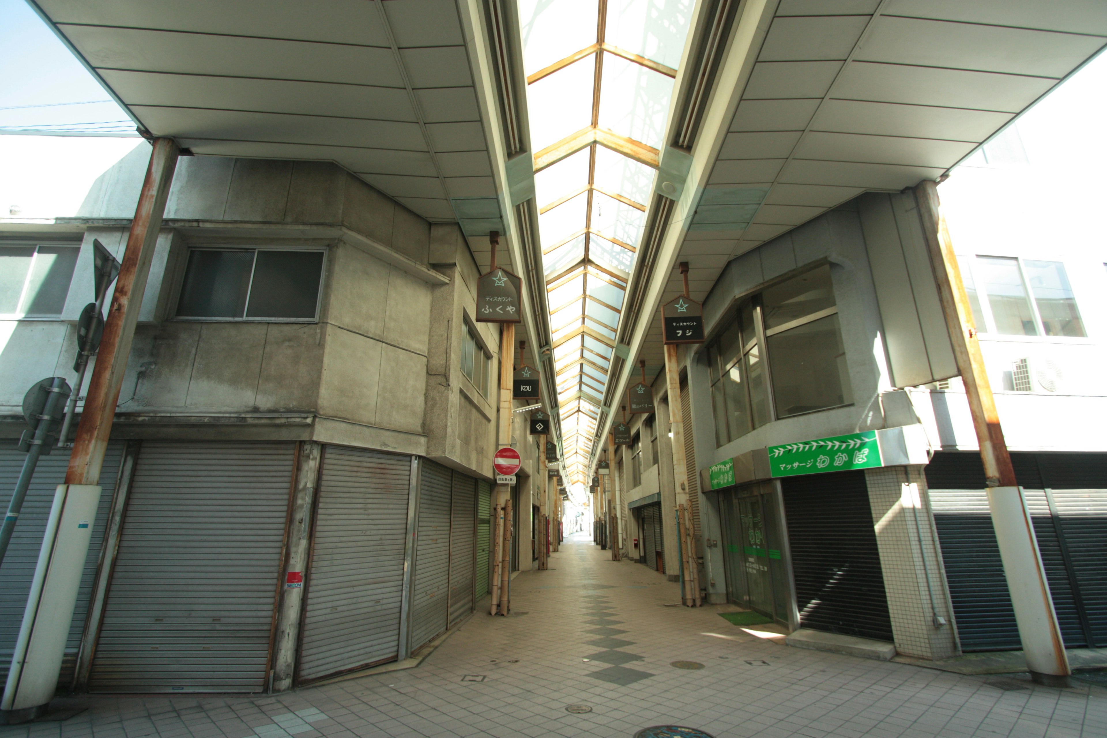 Foto de una calle comercial vacía con tiendas cerradas a ambos lados