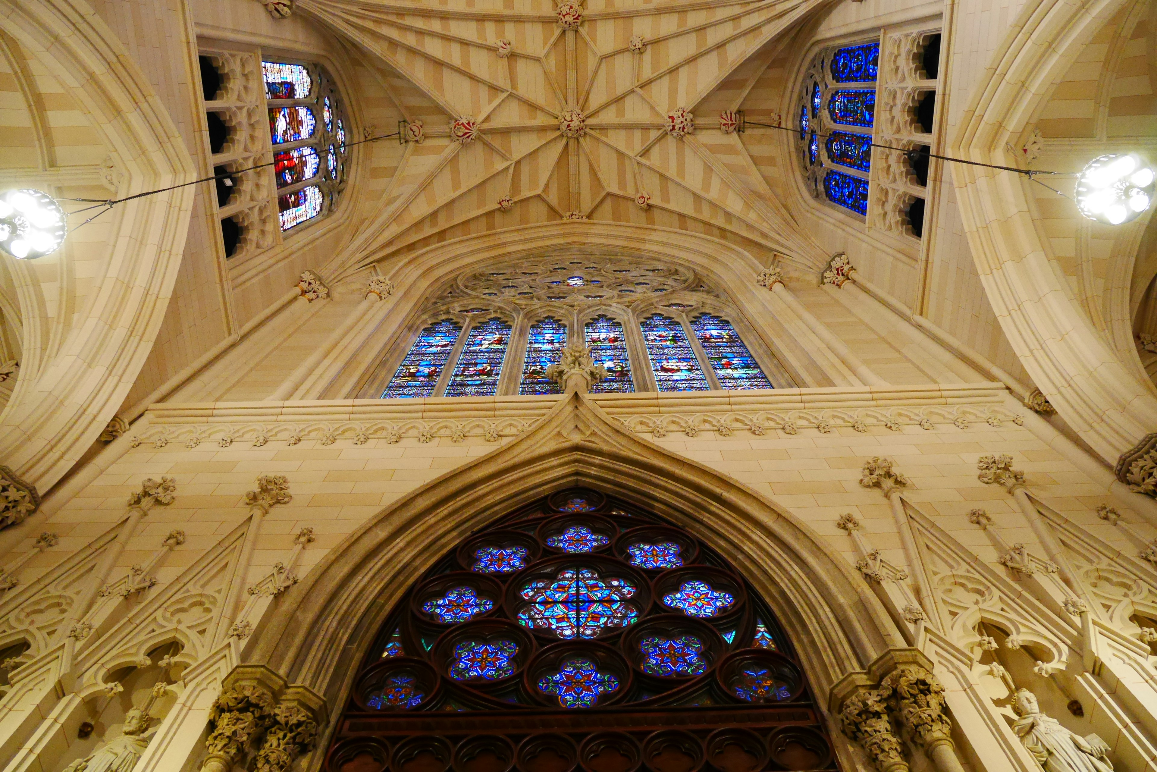 Interior of a cathedral featuring beautiful arching ceilings and colorful stained glass windows