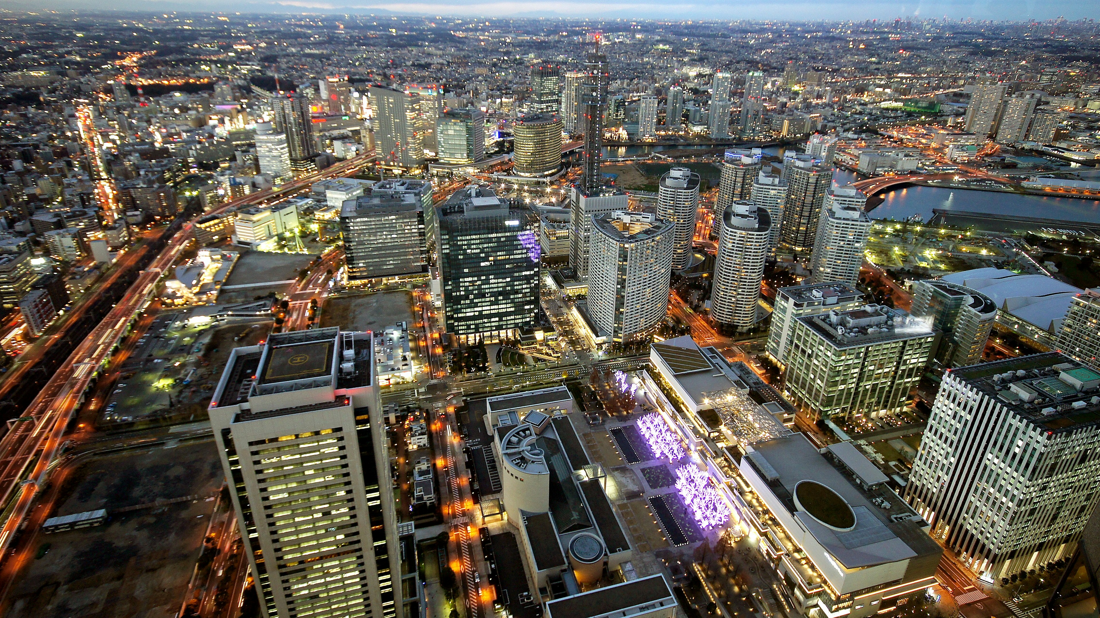 Aerial view of a city skyline at night featuring skyscrapers and illuminated streets