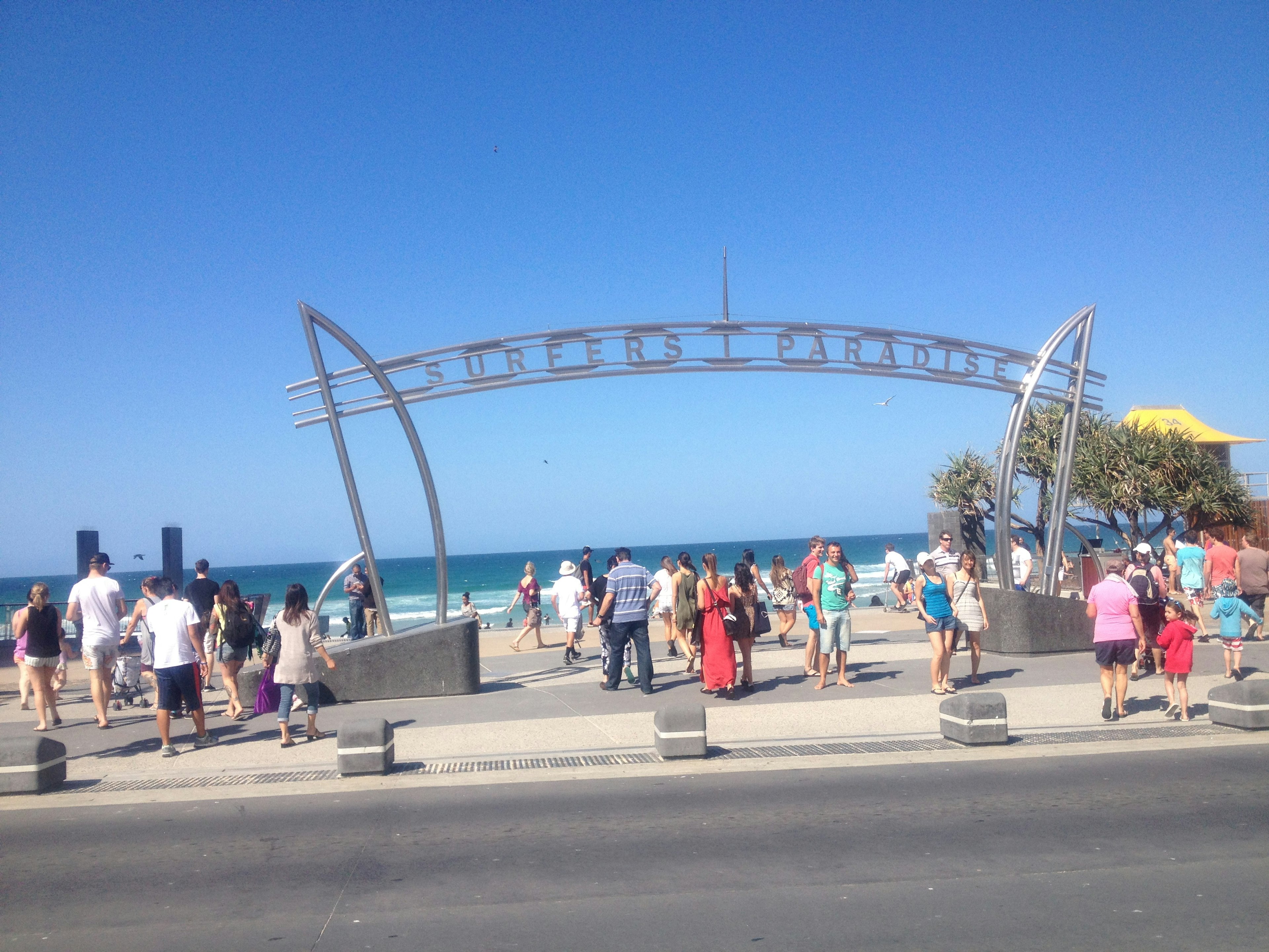 Crowd of people at a beach with a blue ocean and clear sky