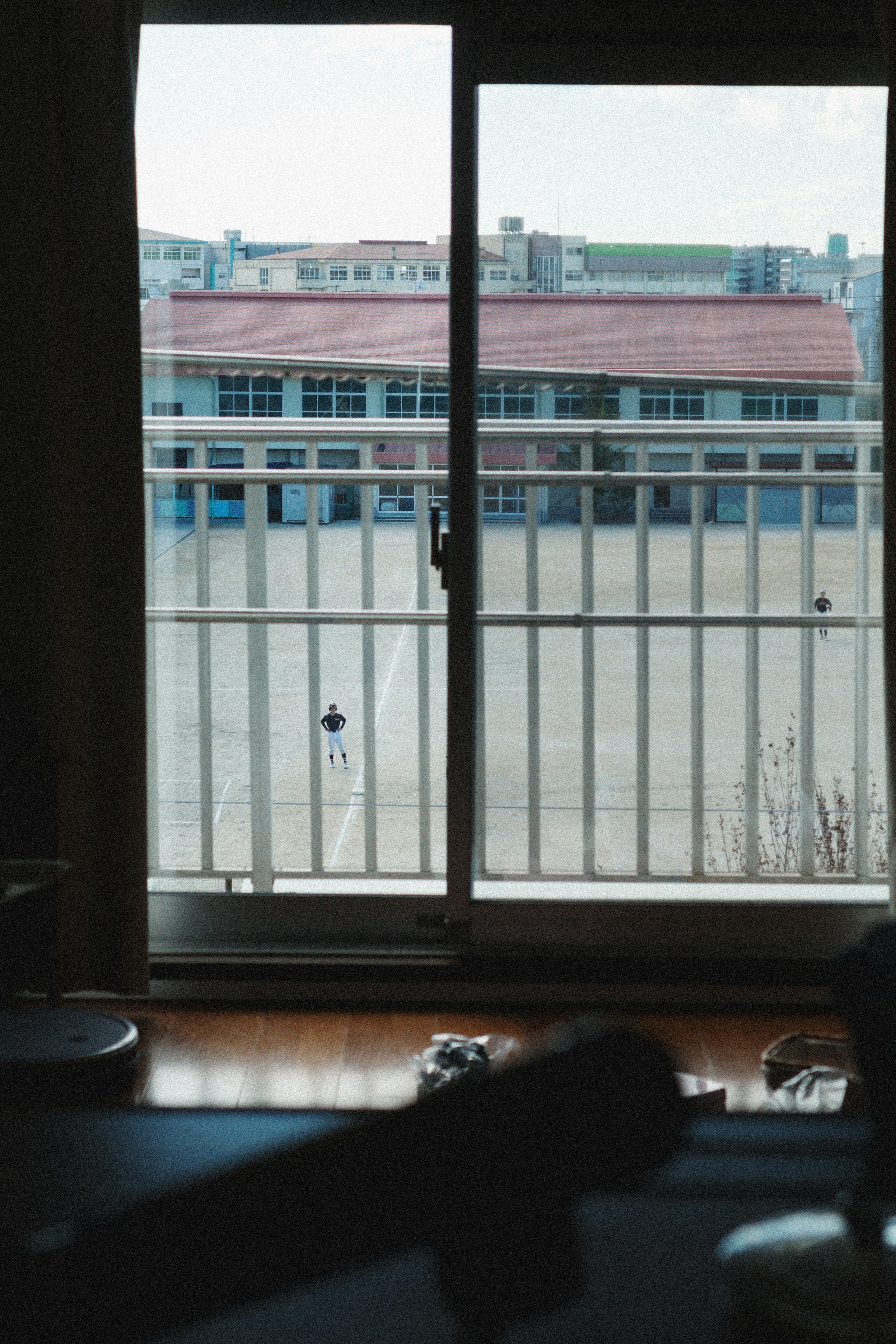 Vista di un edificio scolastico attraverso una finestra con un balcone