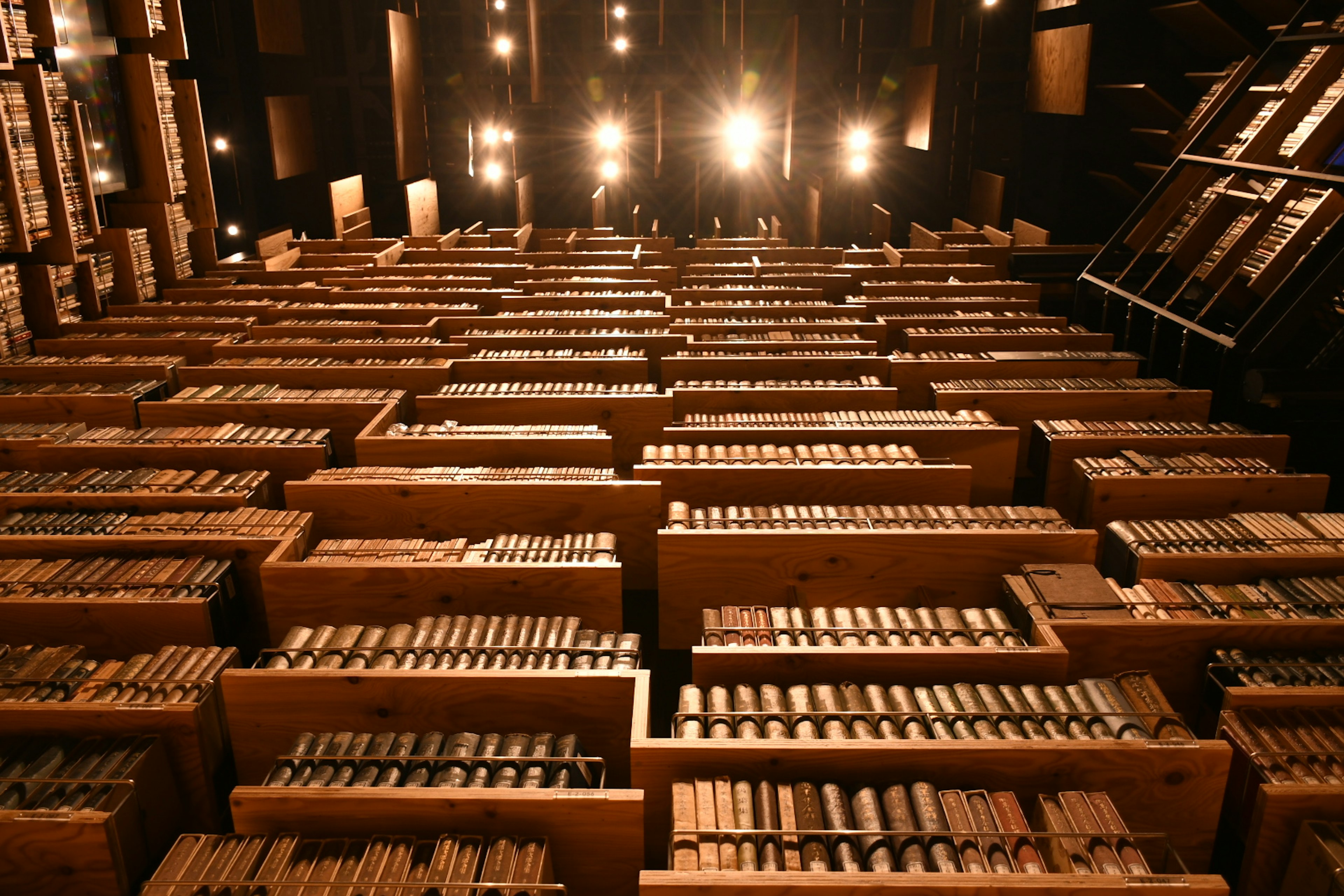 A space filled with rows of wooden drawers illuminated by lights