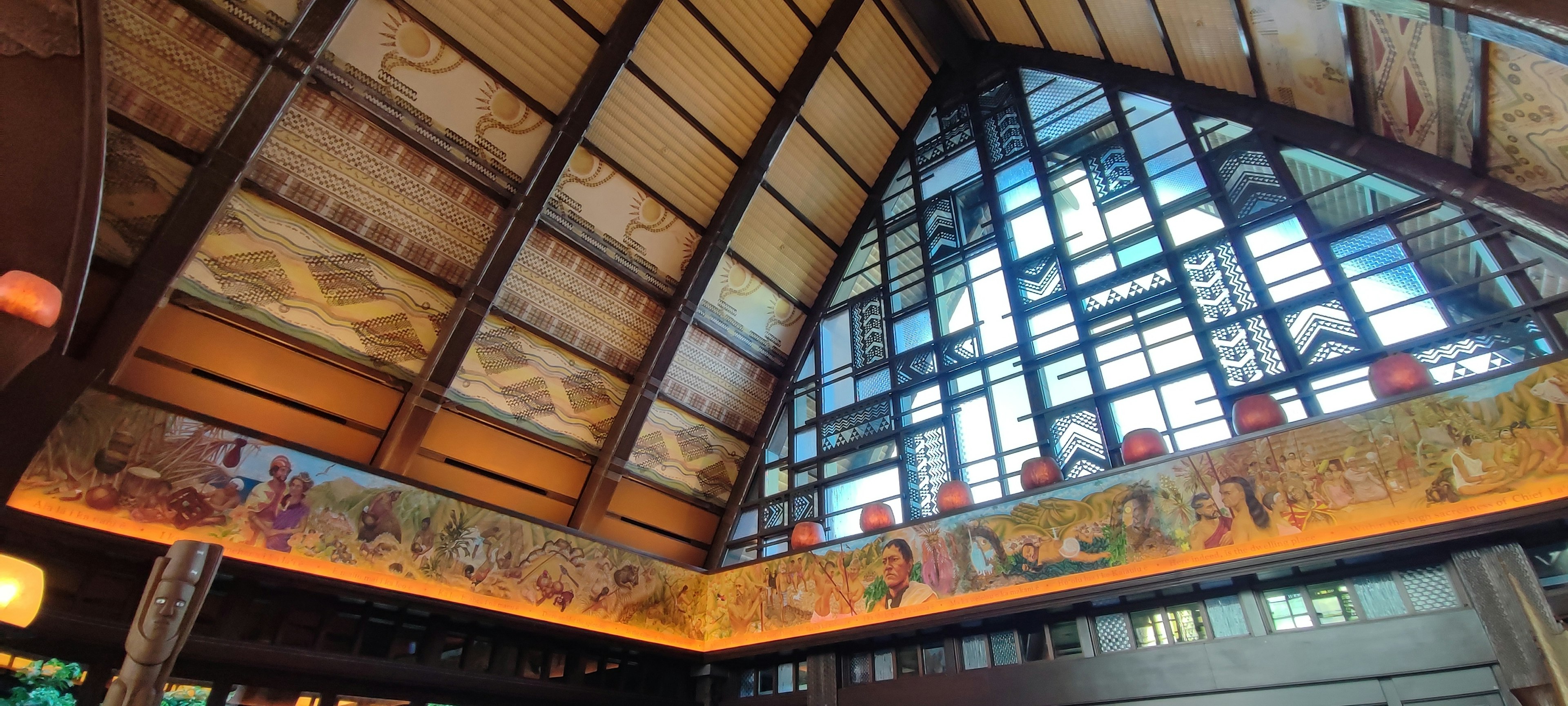 Intérieur d'un bâtiment avec un plafond haut des fresques décoratives et de grandes fenêtres