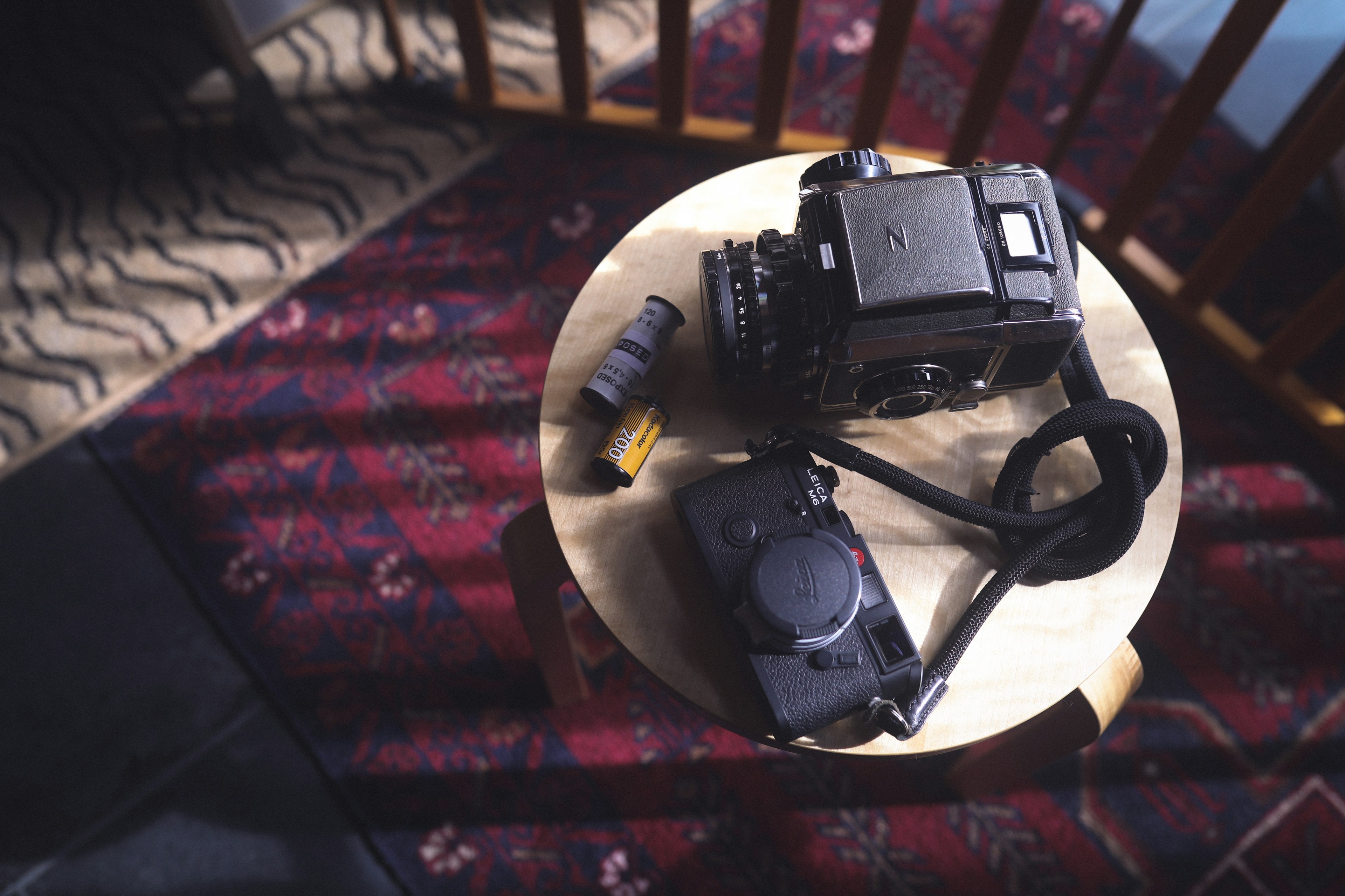 Still life photo of a camera and lens on a wooden table