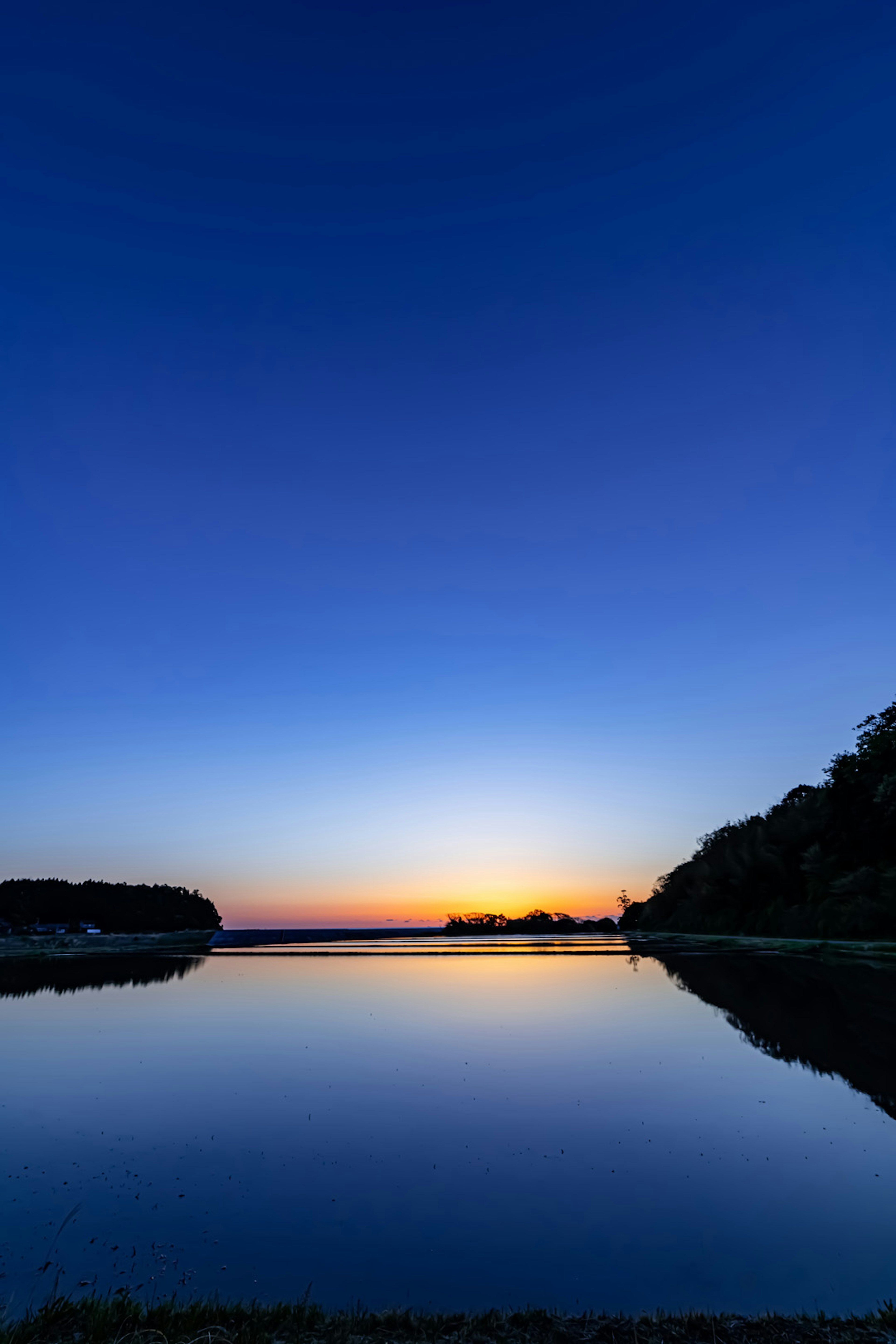 Scena tranquilla di un lago al tramonto con cielo colorato