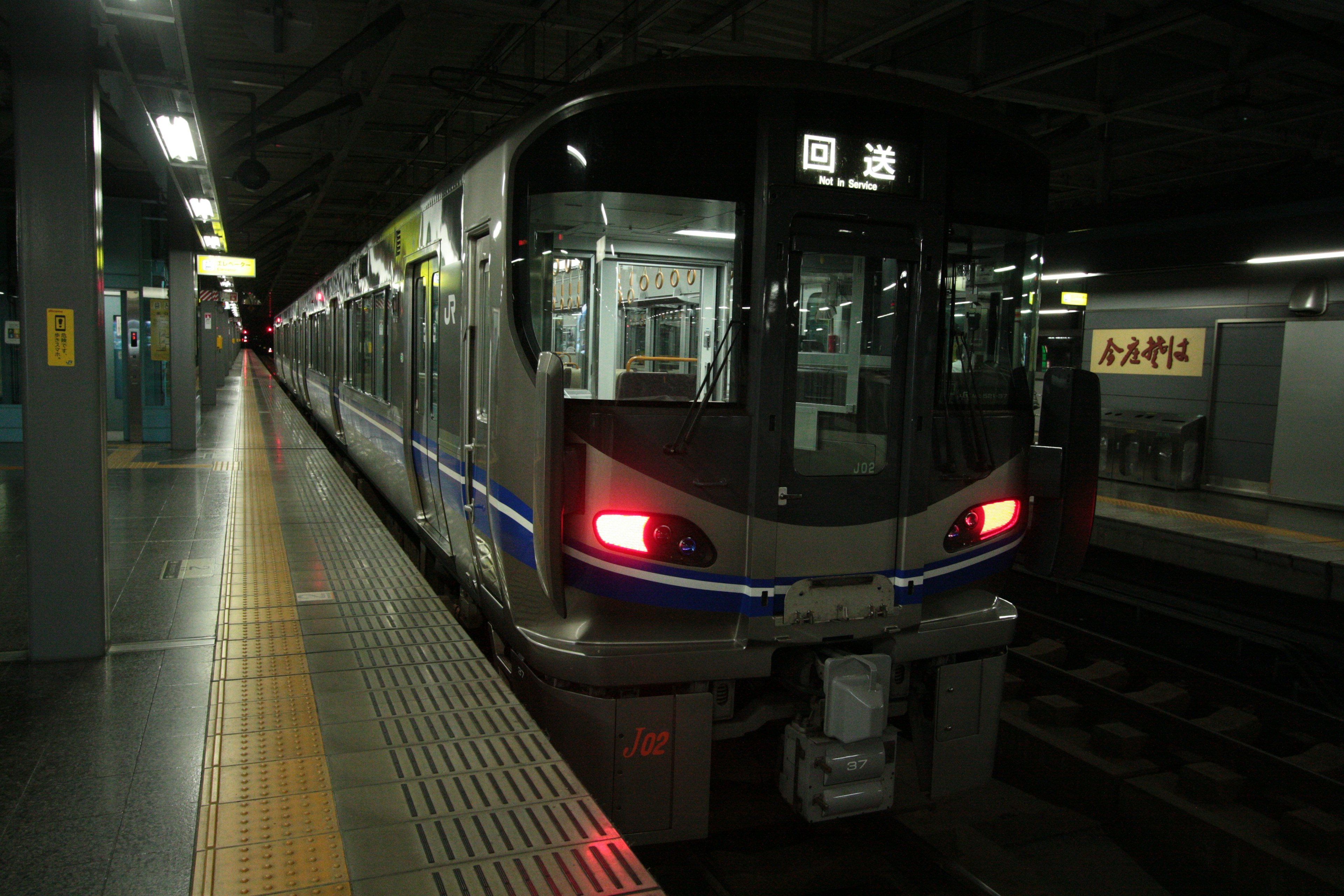 Tren moderno en una plataforma de estación poco iluminada