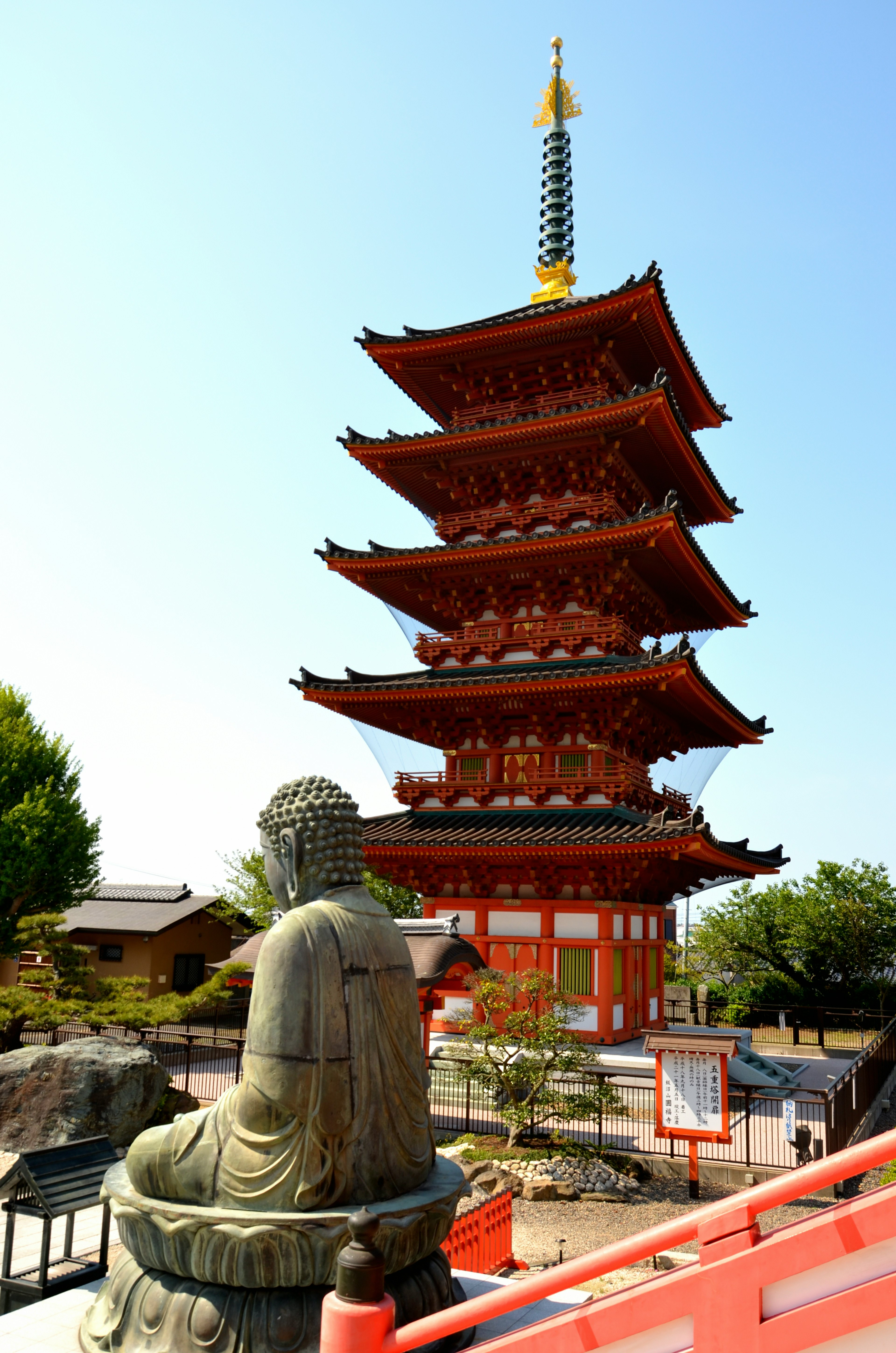 Red five-story pagoda with a seated Buddha statue