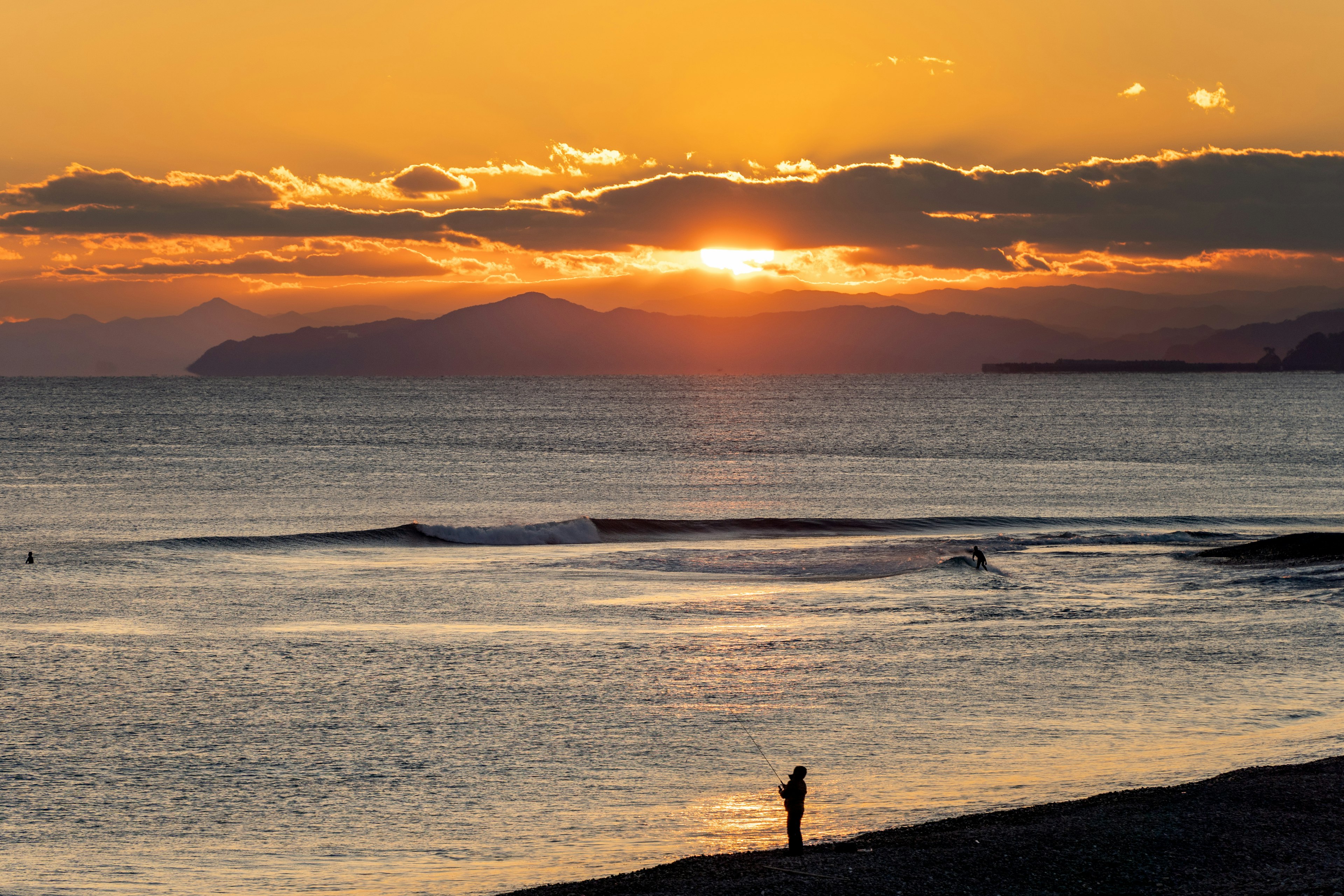 夕日が海に沈む美しい風景とシルエットの人物