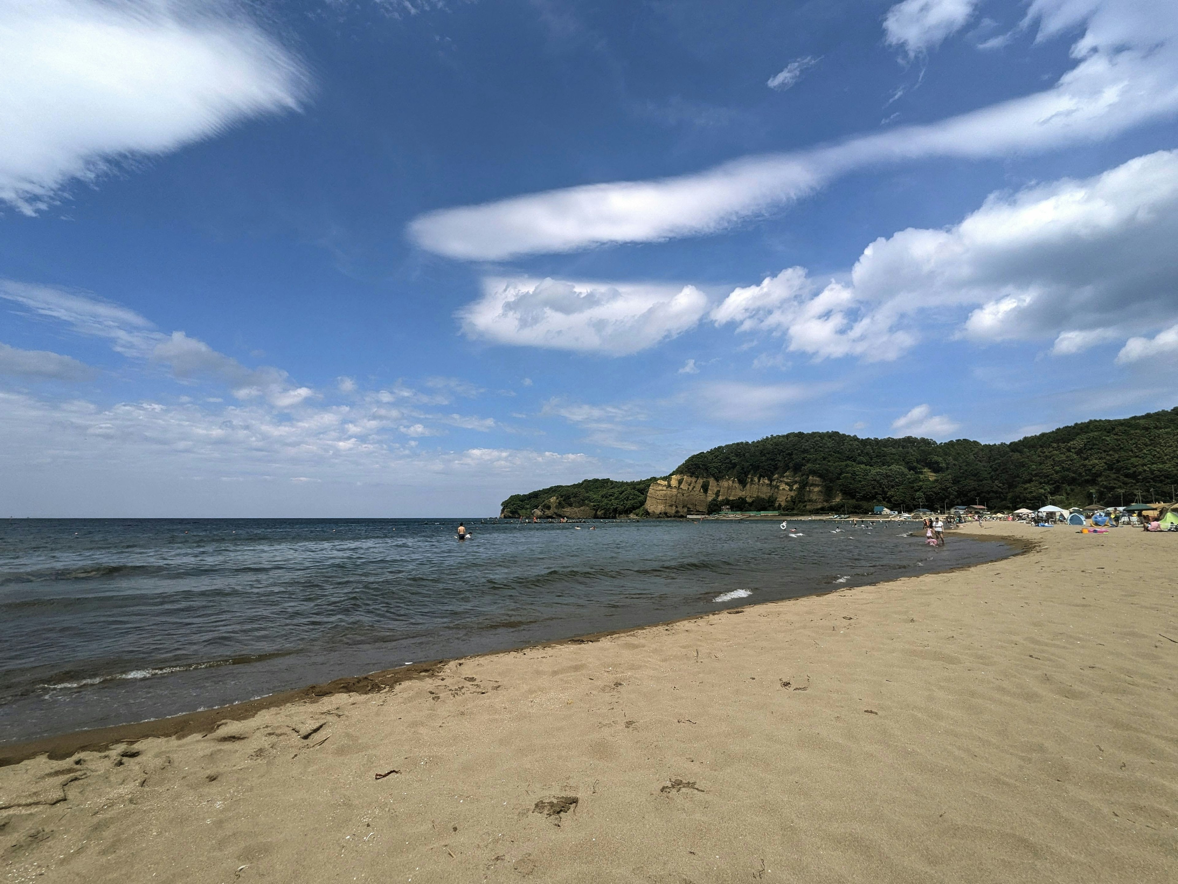 ฉากชายหาดที่มีท้องฟ้าสีฟ้าและเมฆสีขาวชายหาดทรายและมหาสมุทร