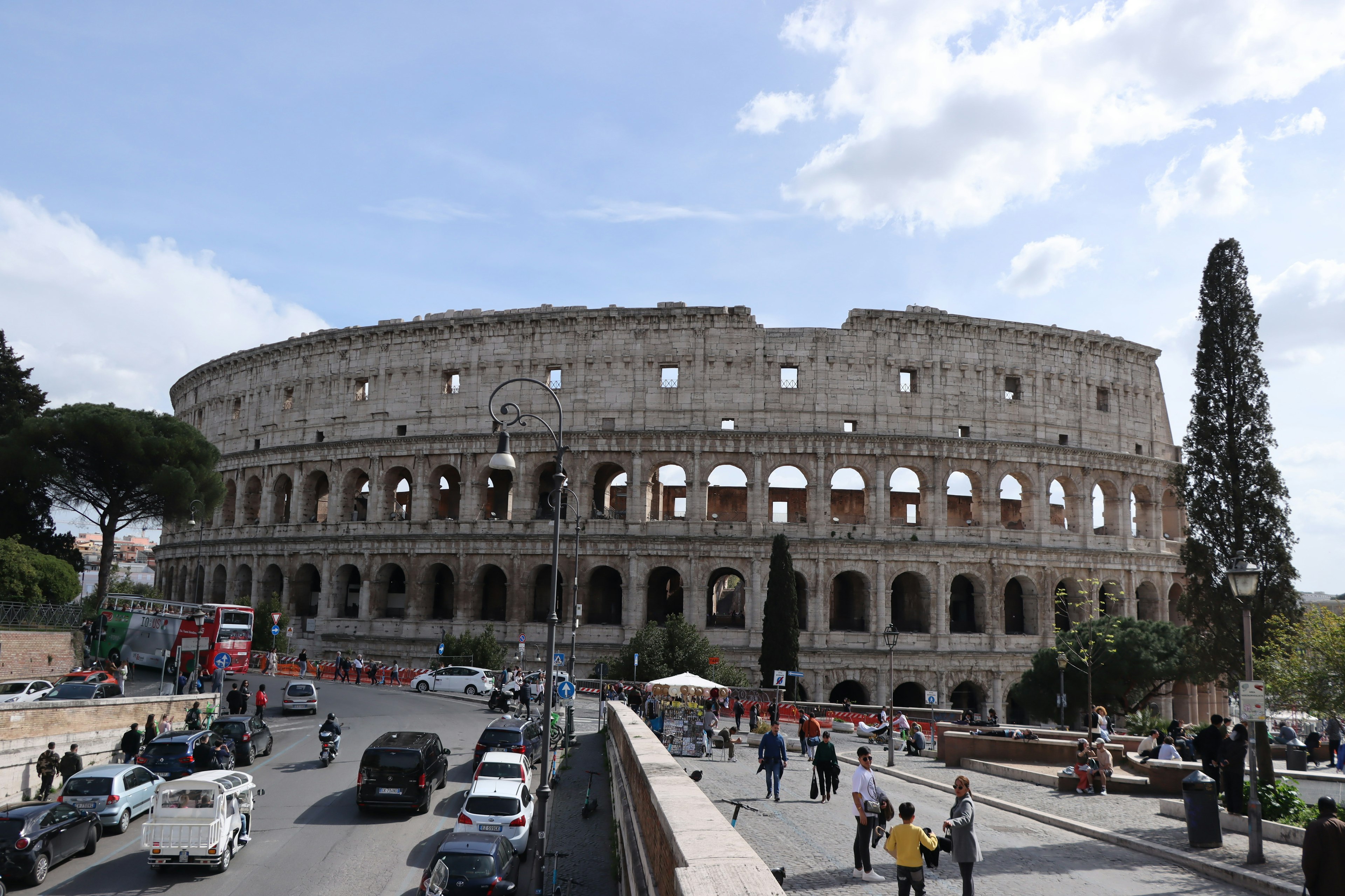 Vista del Colosseo a Roma con il traffico e i visitatori circostanti