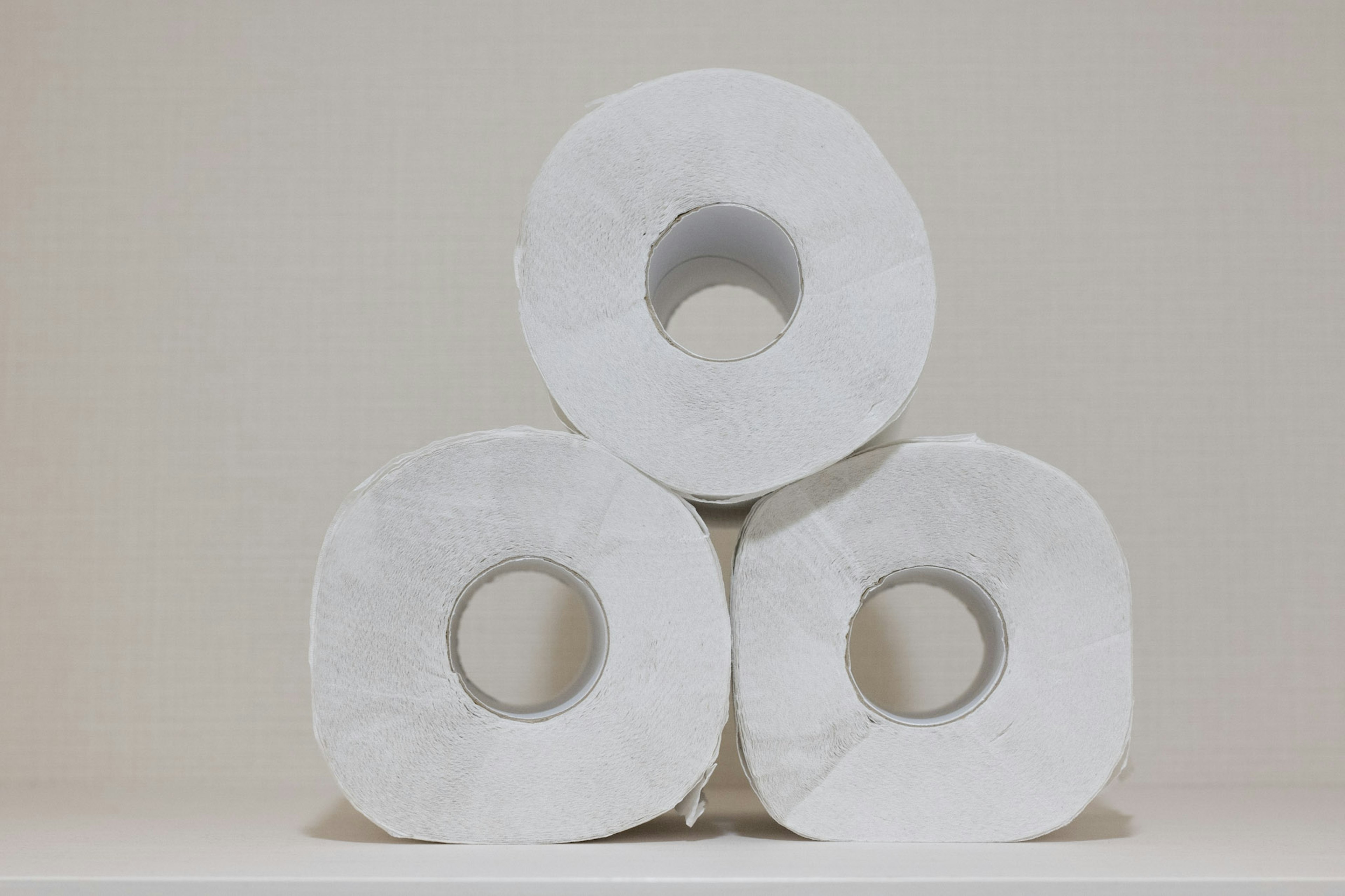 Trois rouleaux de papier toilette empilés dans une composition simple