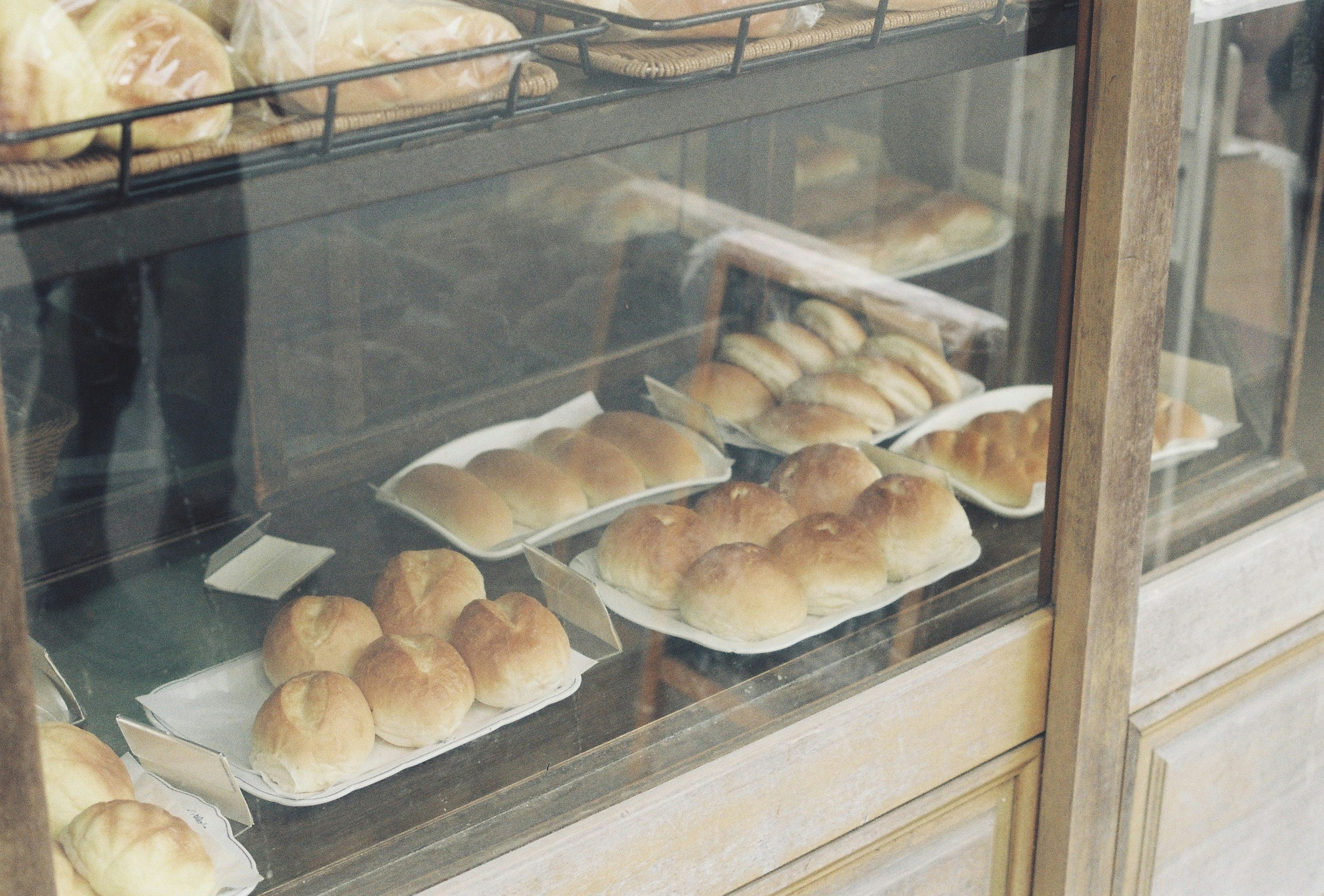 Freshly baked bread and rolls displayed in a glass case