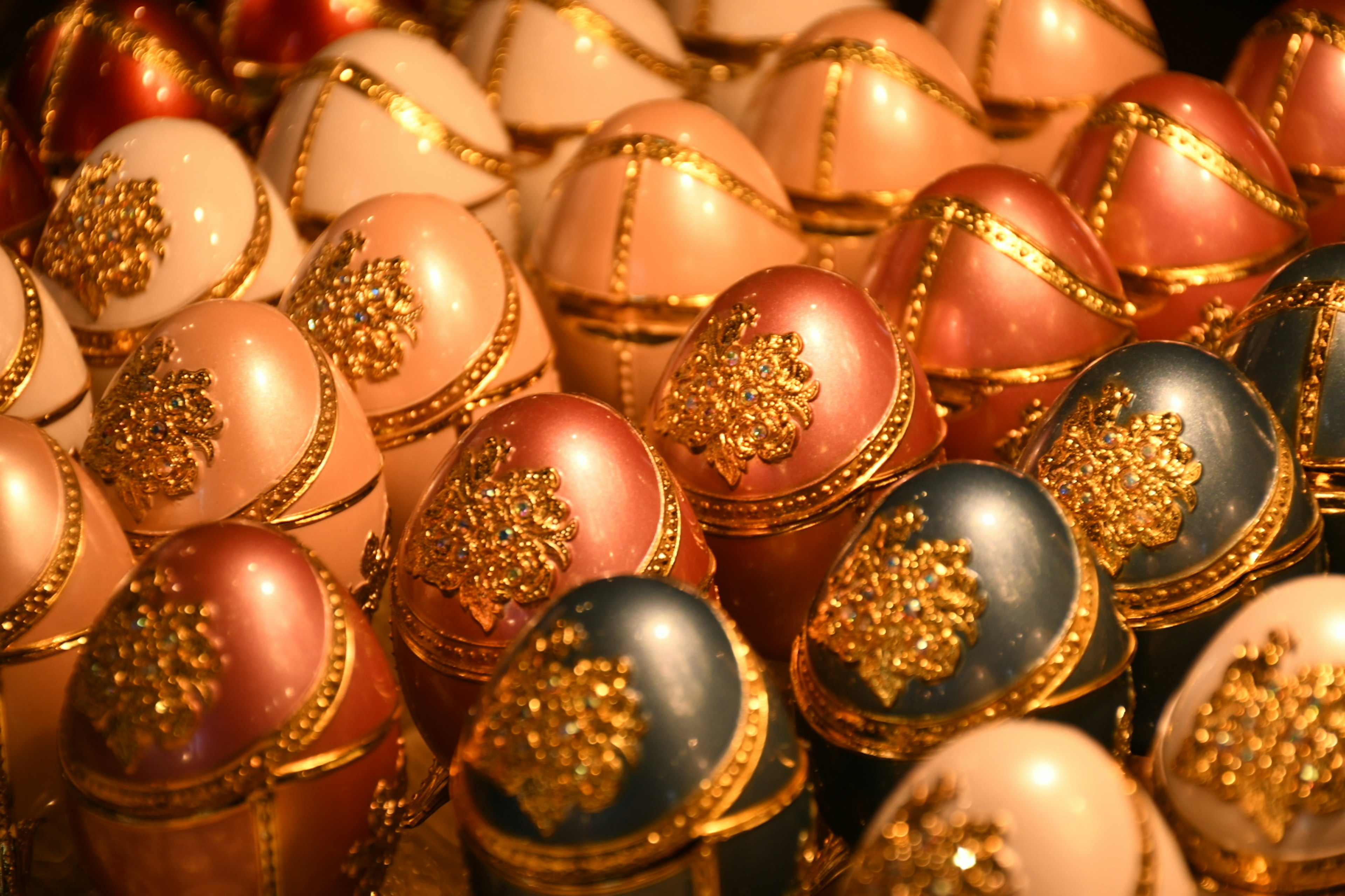 Collection of decorative eggs in various colors with gold embellishments