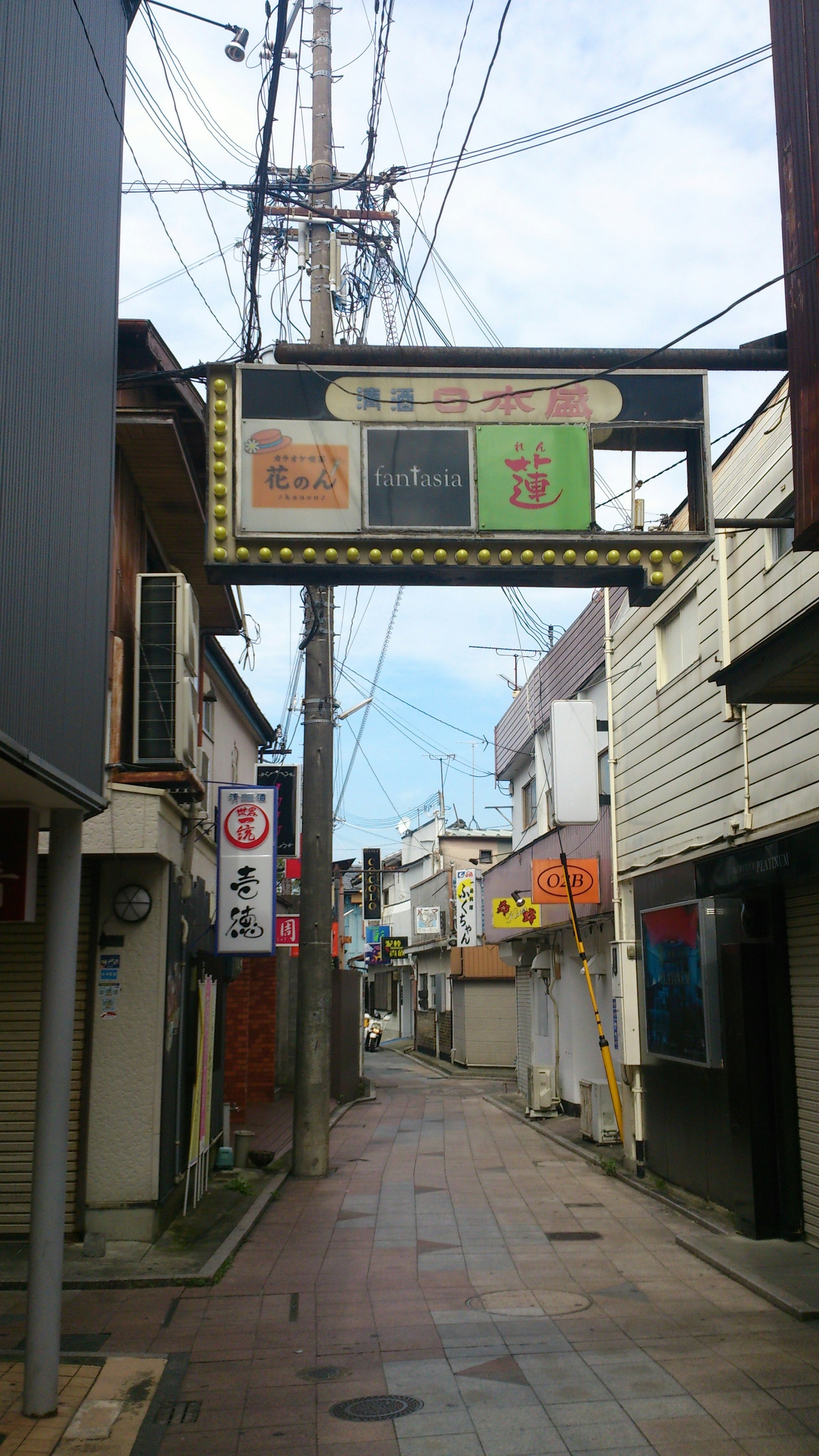 Narrow street with a sign and power lines