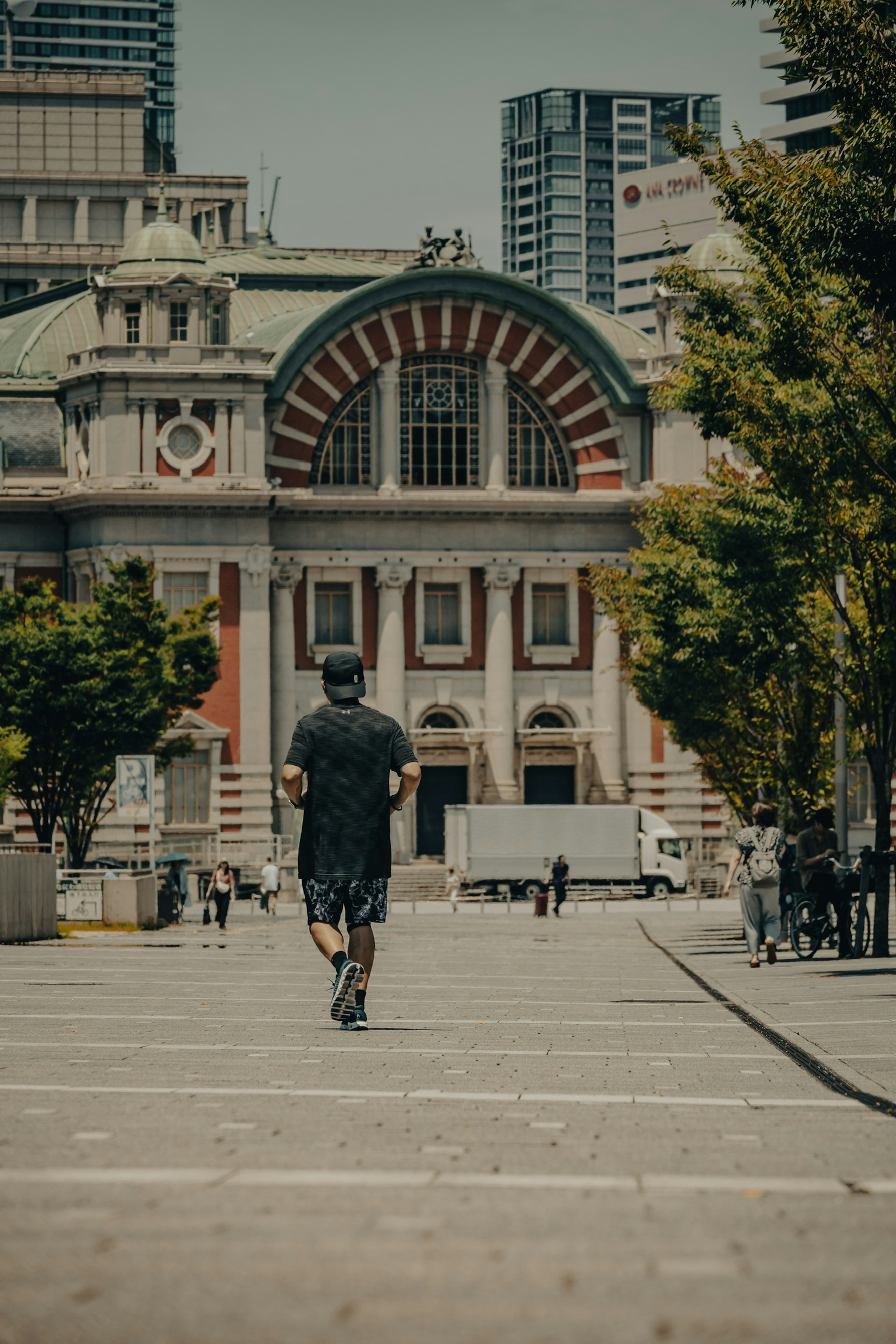 一個人在歷史建築前慢跑，周圍是綠色的樹木