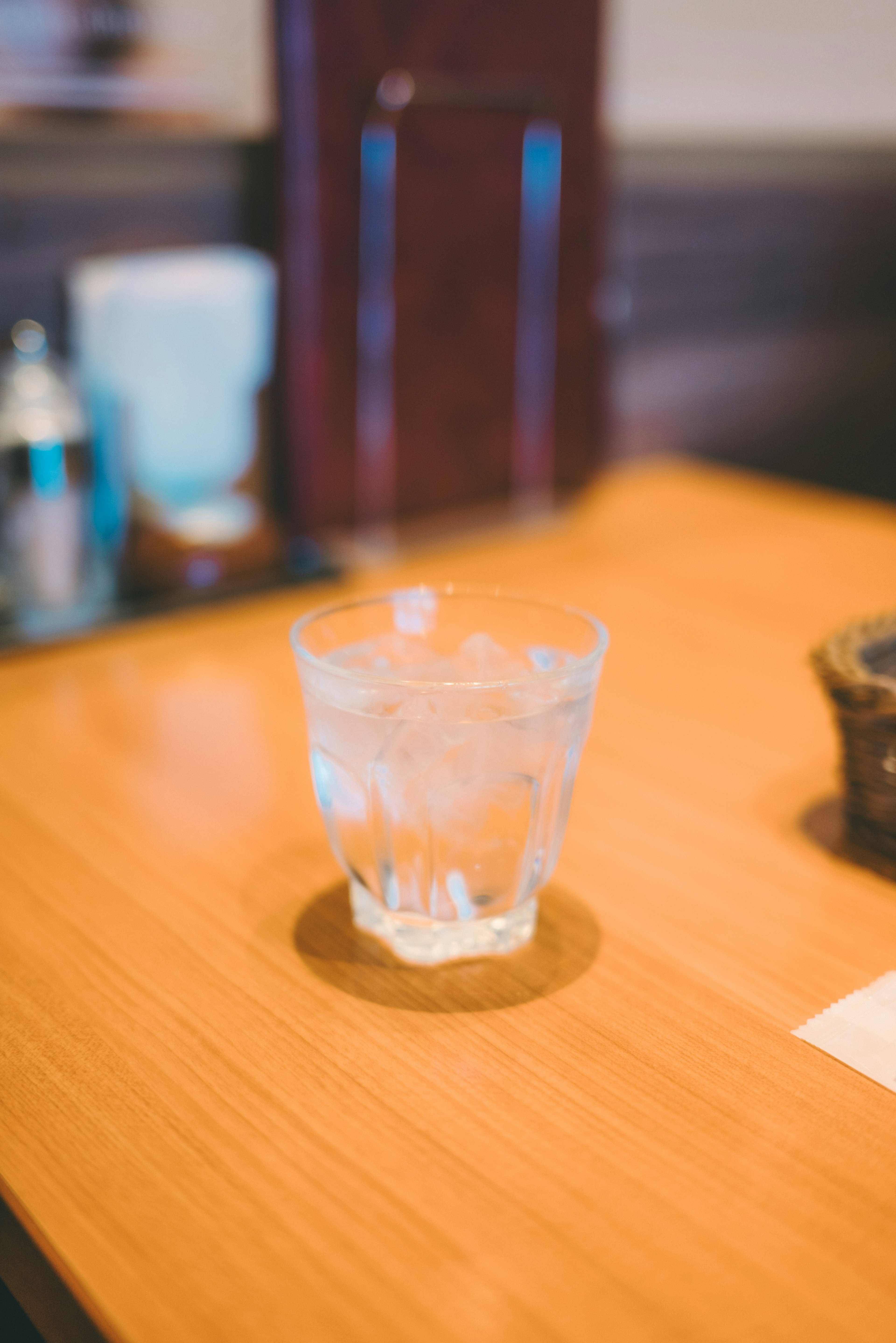 Un vaso de agua con hielo sobre una mesa de madera