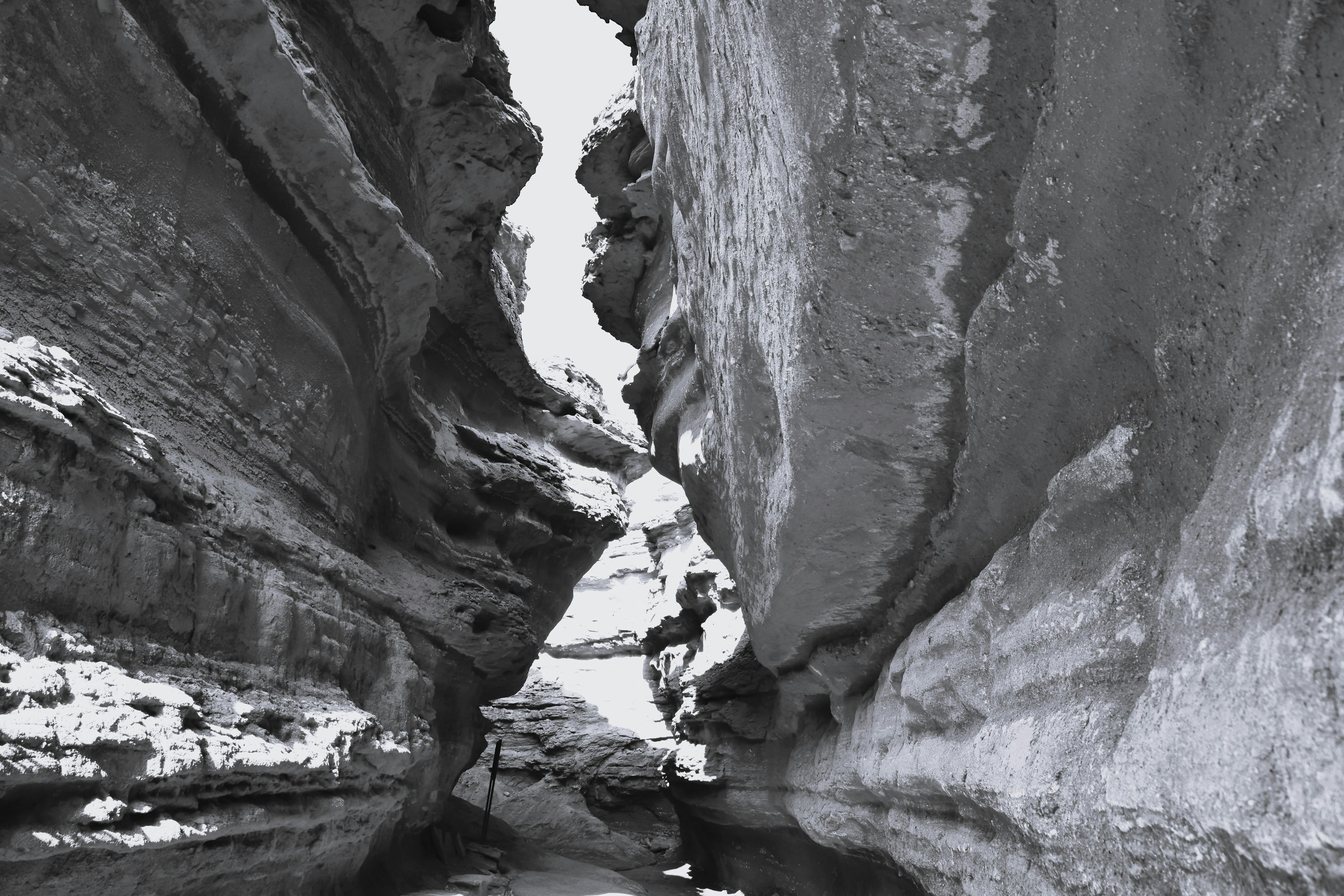 Paesaggio di canyon in bianco e nero con grandi pareti rocciose che creano un passaggio stretto che mostra la bellezza e la forza della natura