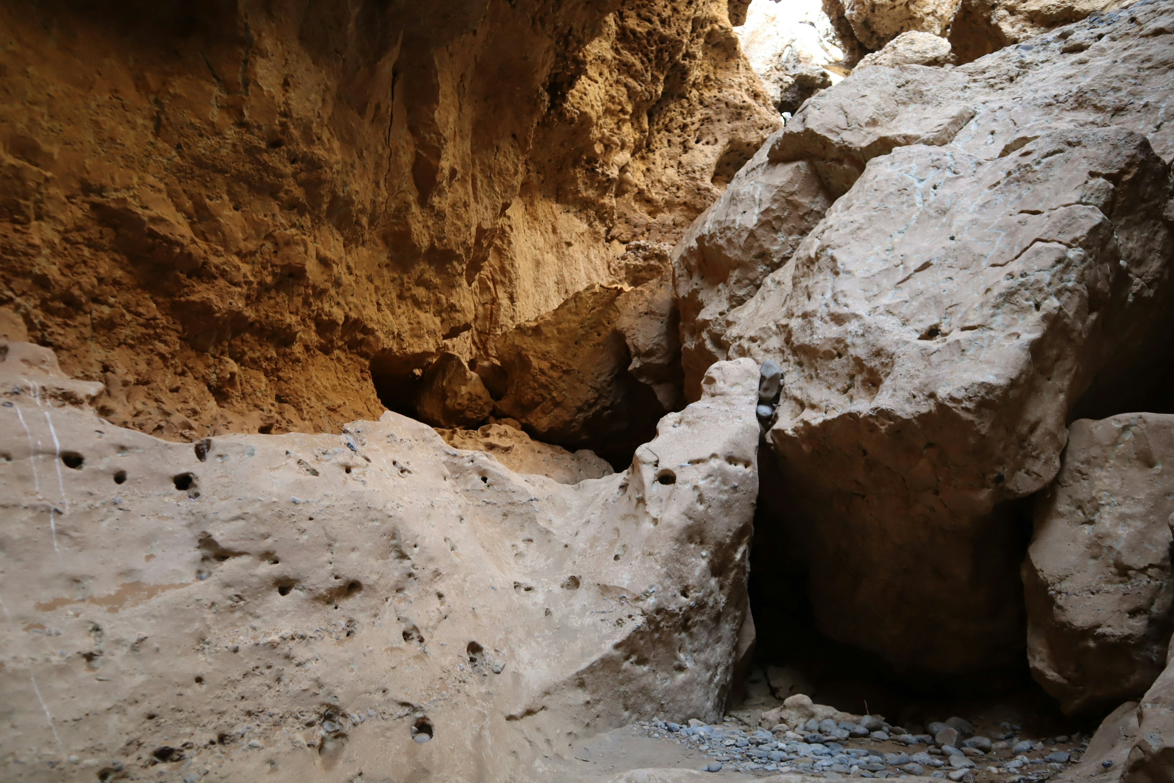 Interior view of a cave with rocky formations and gaps