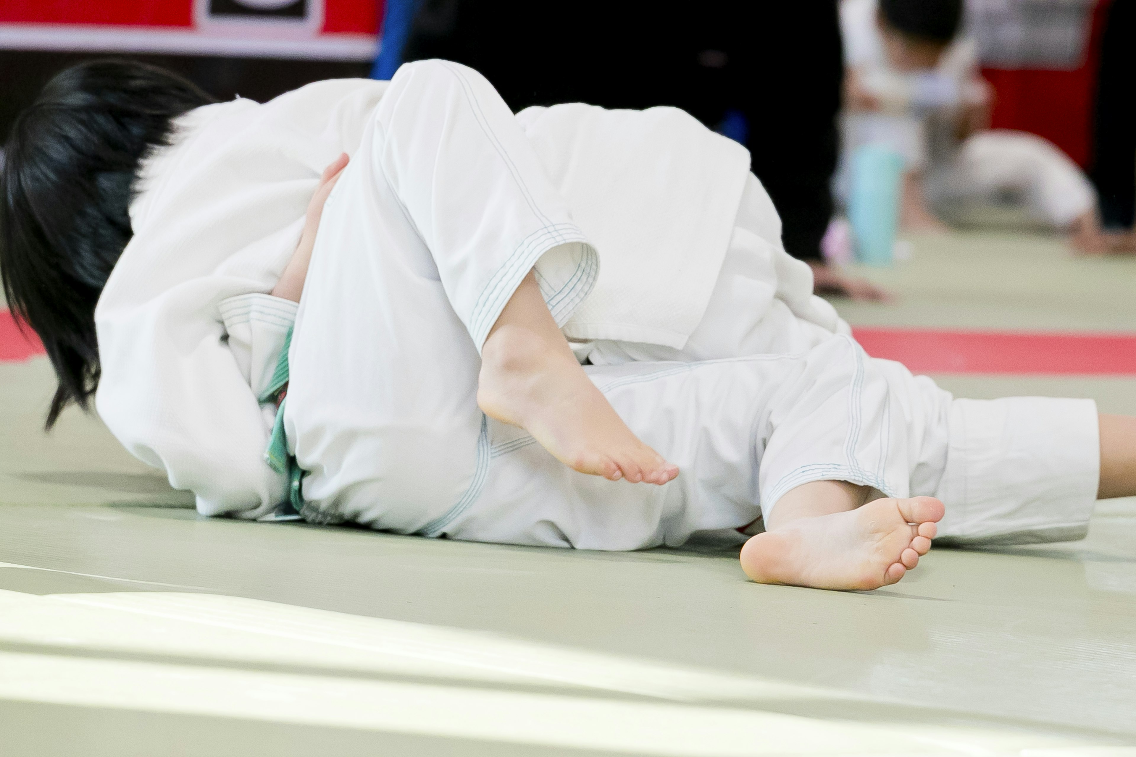 Children practicing judo on a mat in a training session