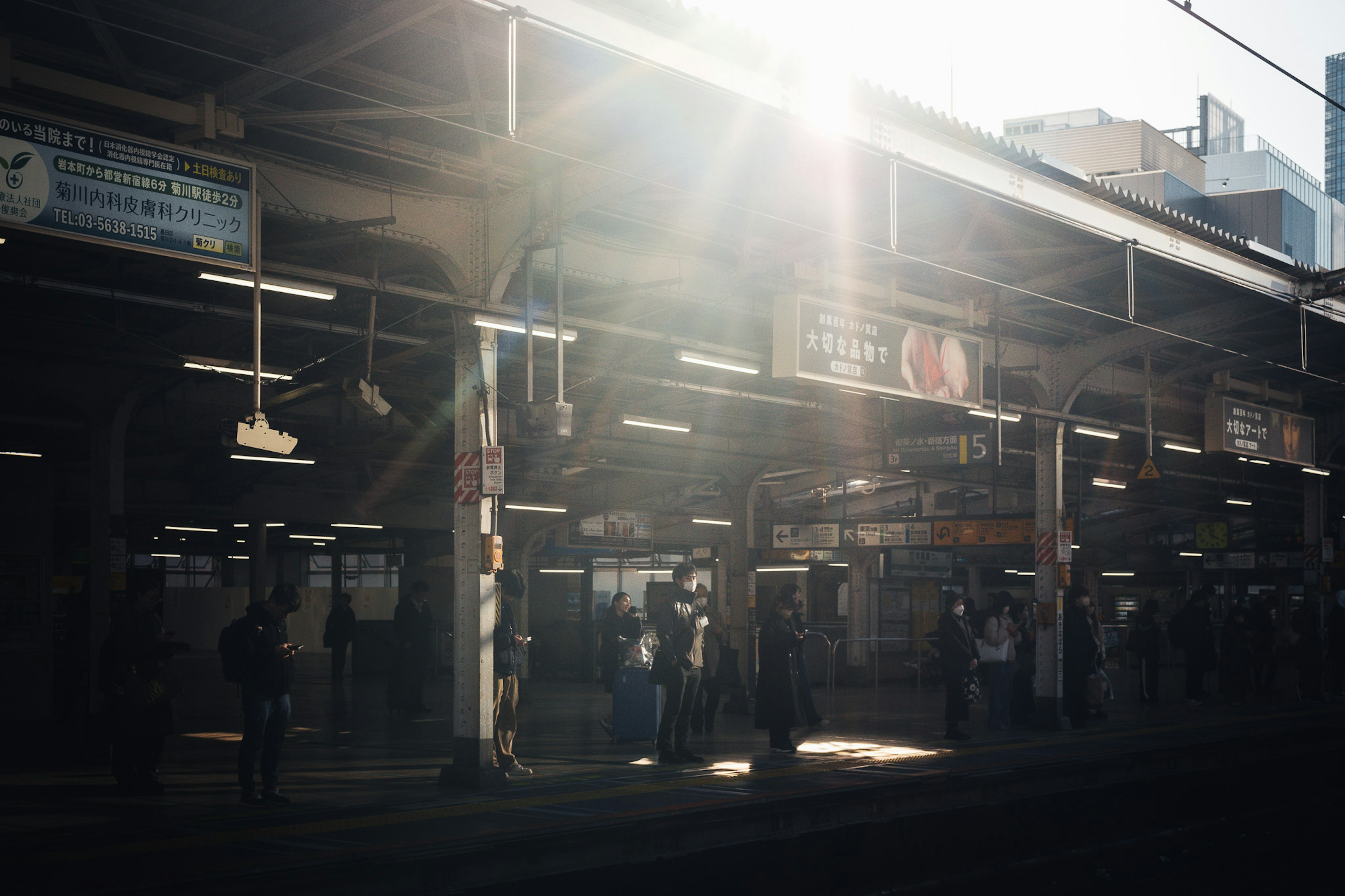 ผู้คนรออยู่ที่ชานชาลารถไฟพร้อมกับแสงแดดที่ส่องสว่าง