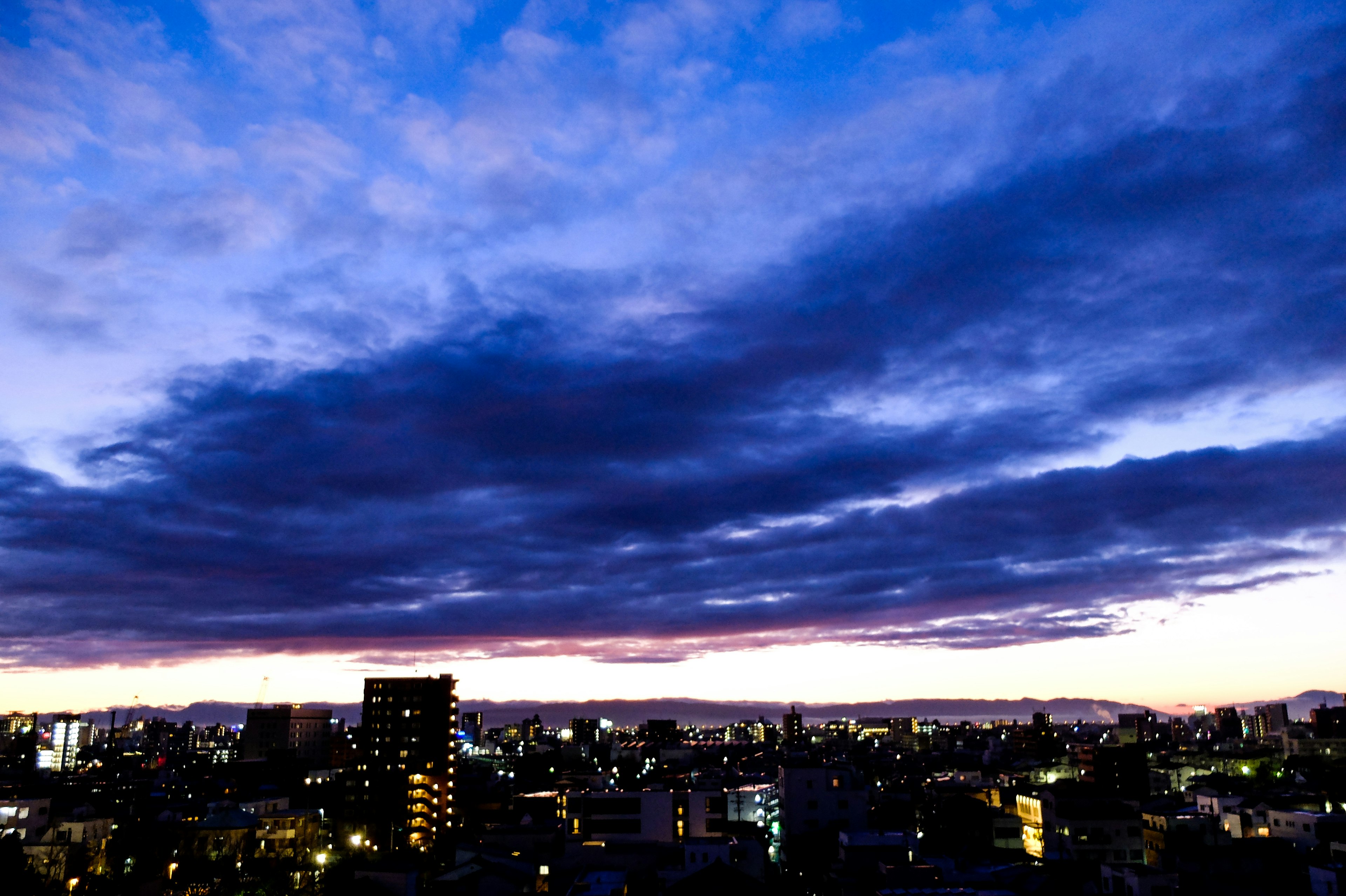 黃昏時的城市天際線與生動的藍紫色雲朵