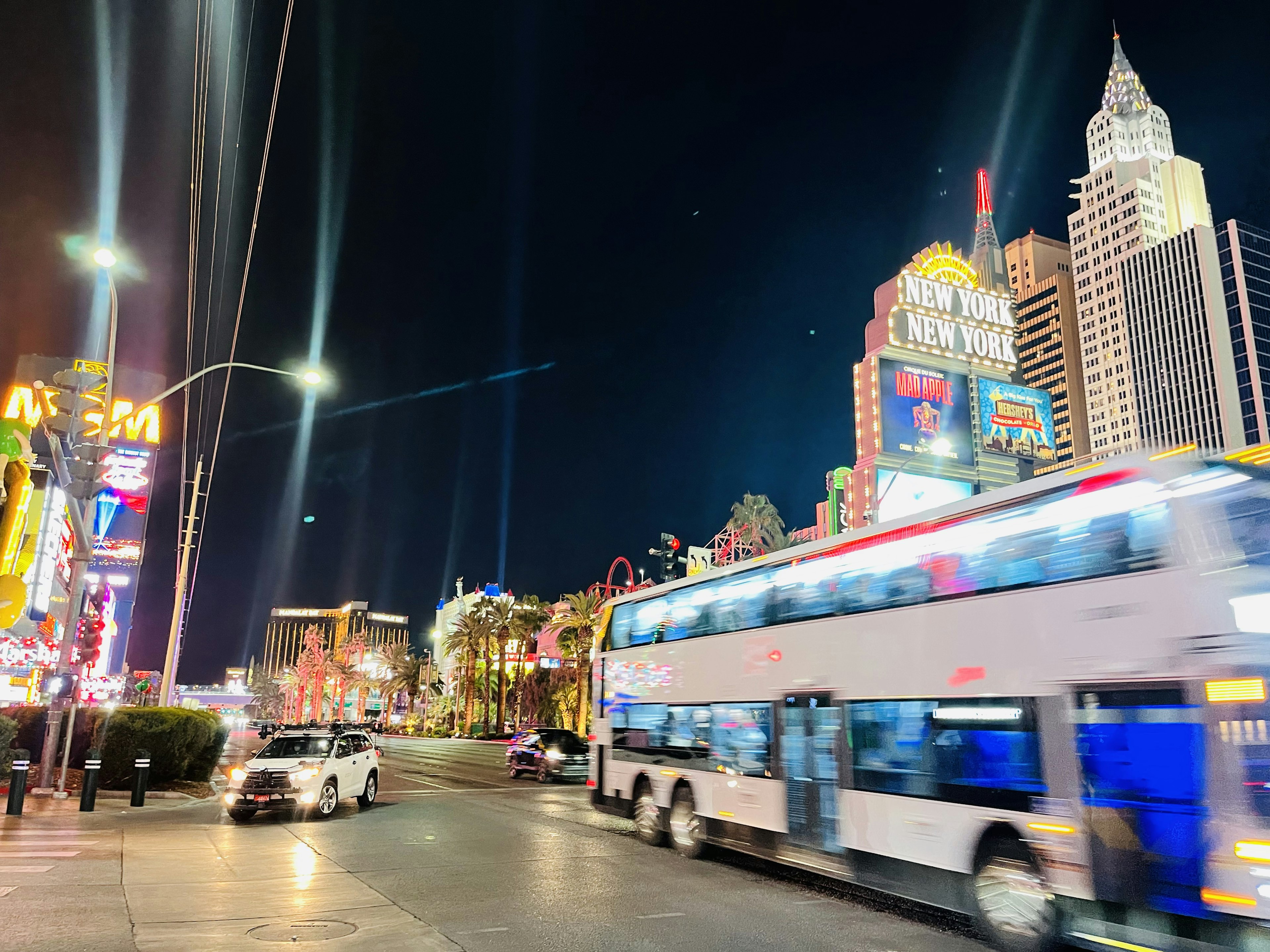 Vista nocturna de Las Vegas con luces de neón y un autobús en movimiento