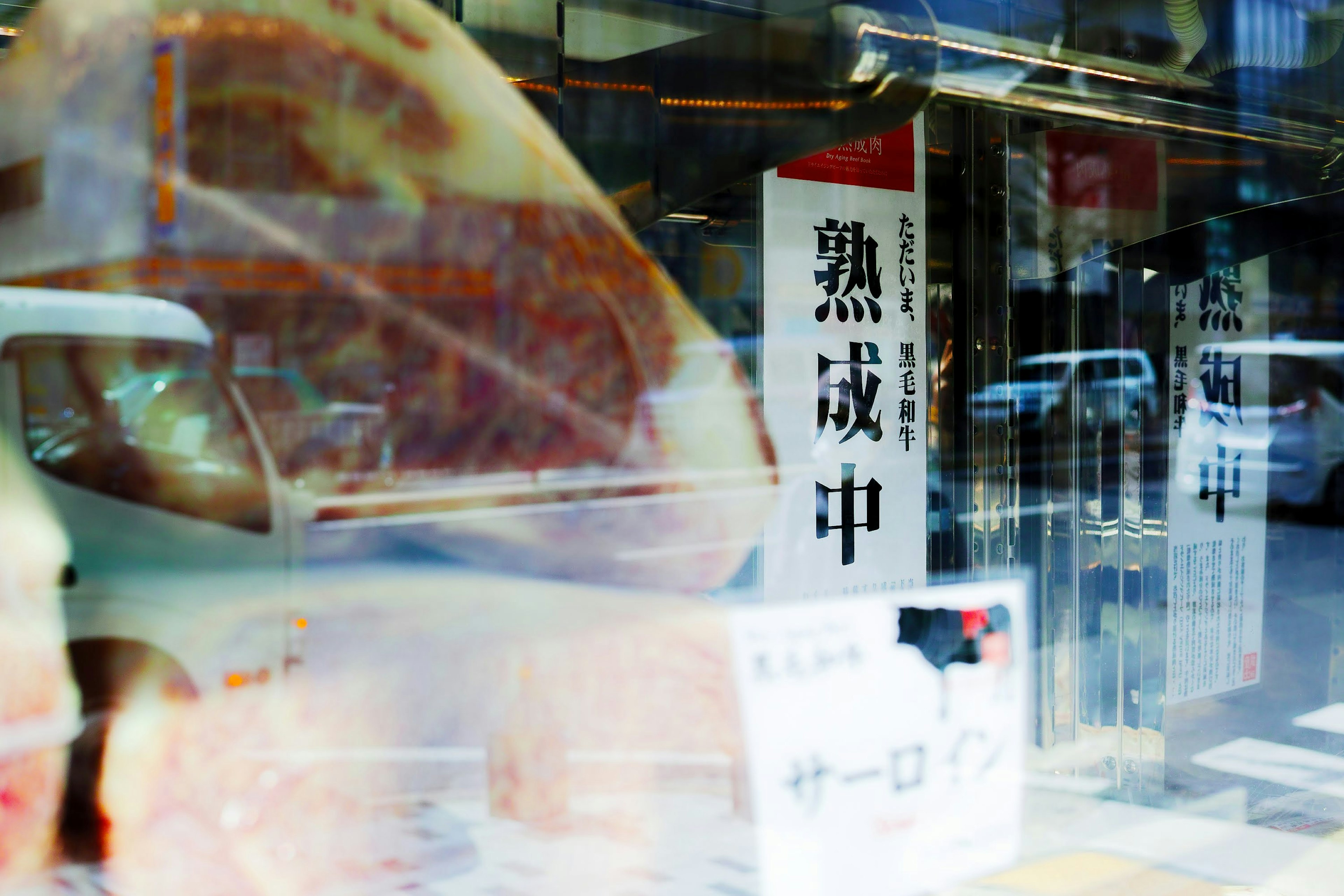 A display window featuring aging meat and signs