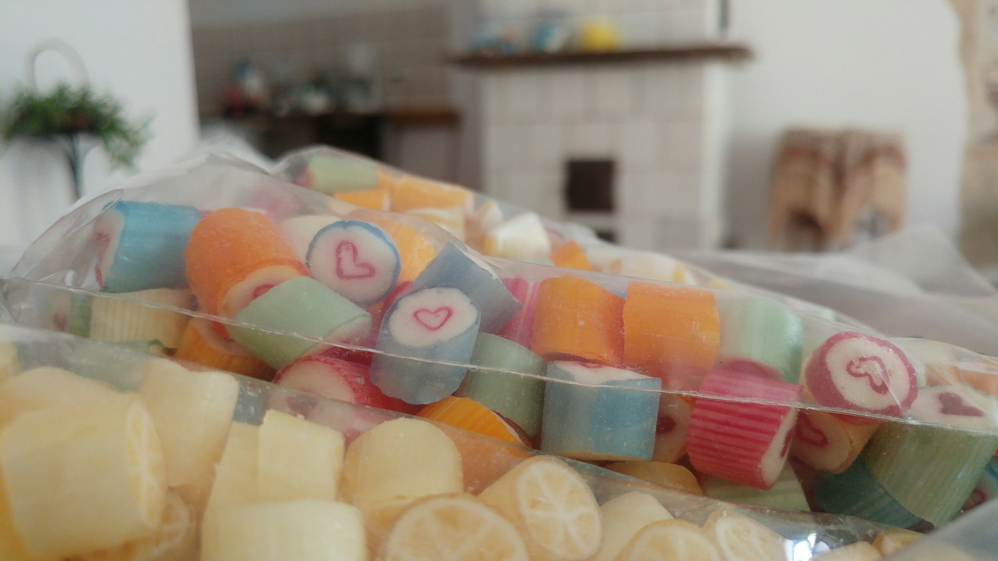 A bag of colorful candies with heart designs in a cozy room setting