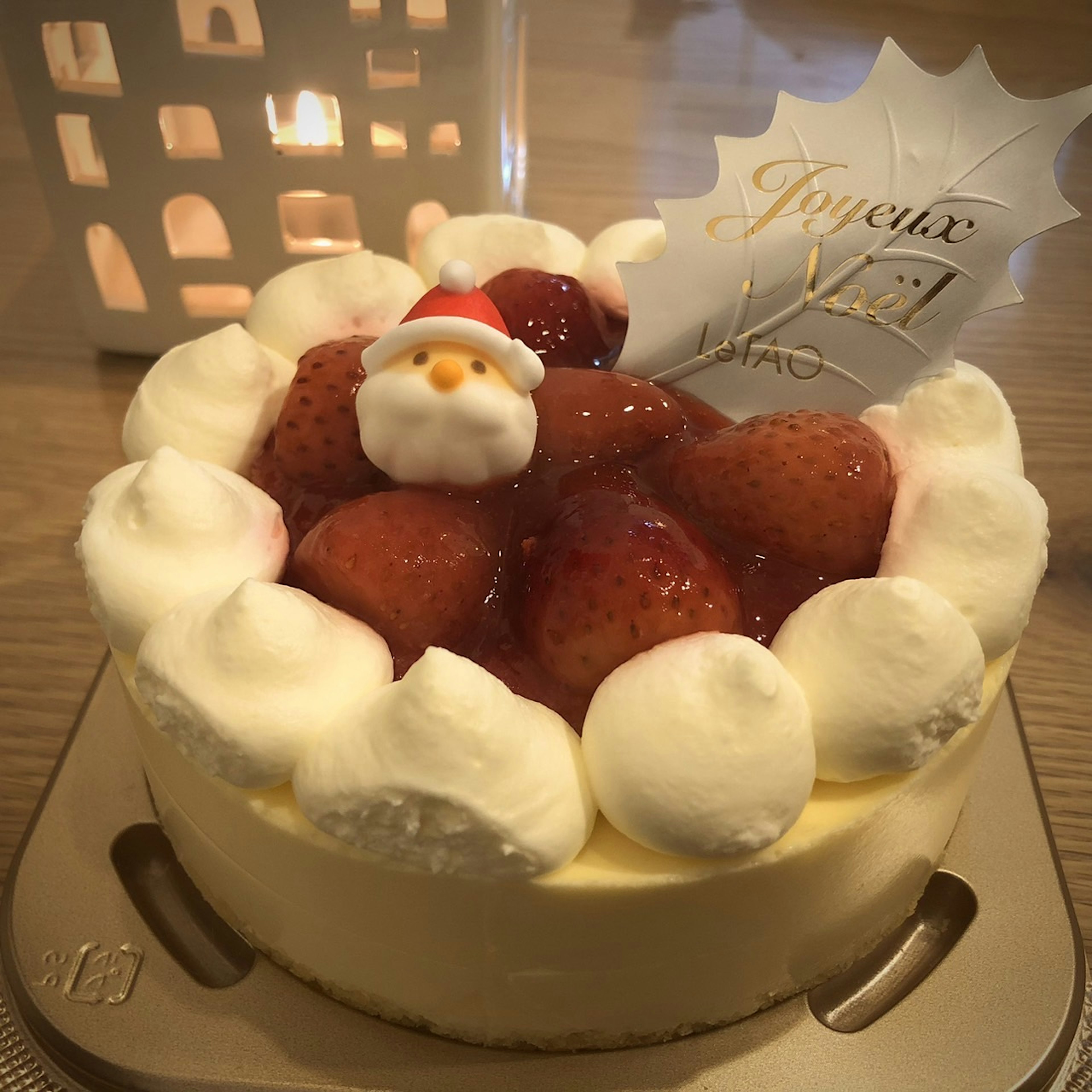 Strawberry cake topped with Santa decoration and whipped cream for Christmas